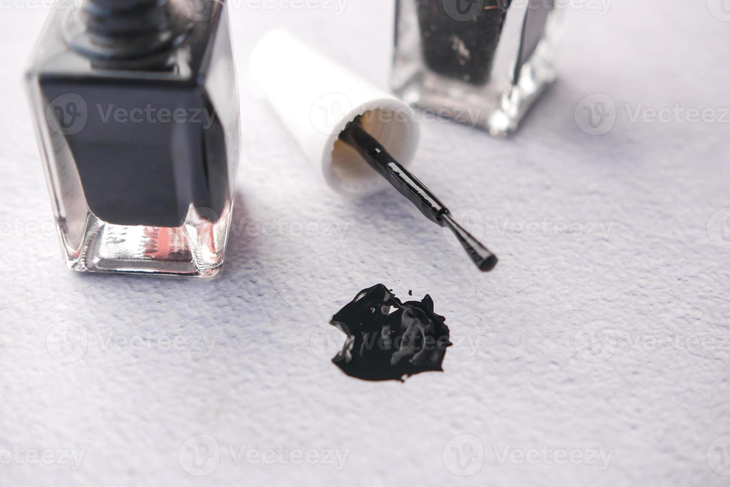 black color nail polish spilling on table photo