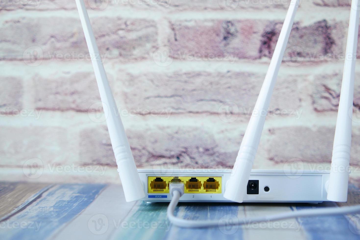 Wi-Fi router with cables on table photo