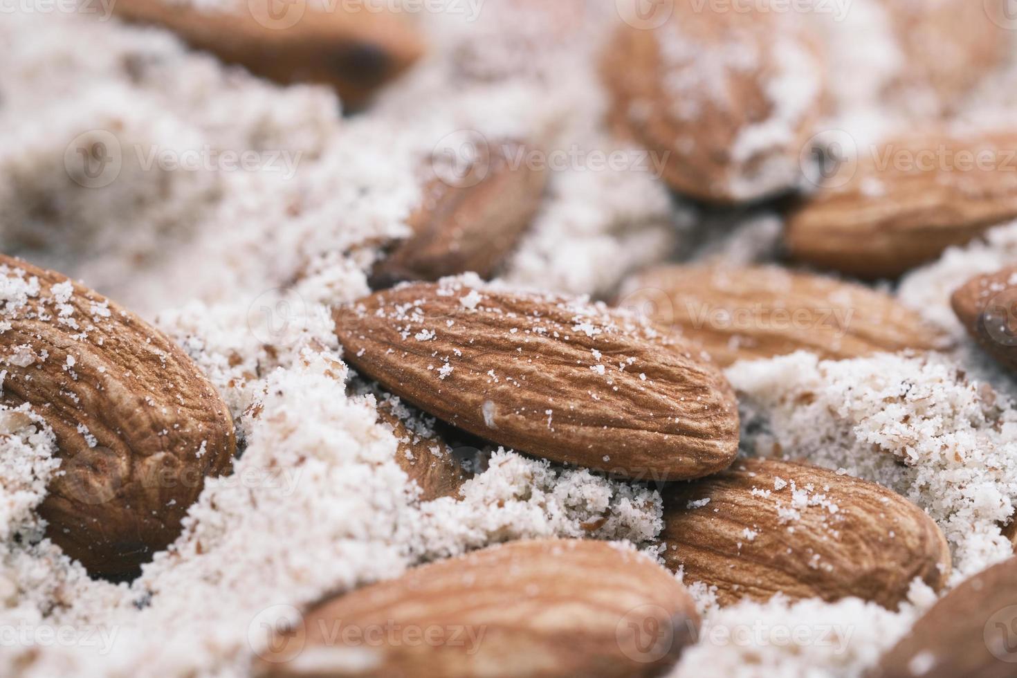 close up of almond and power in a bowl on table photo