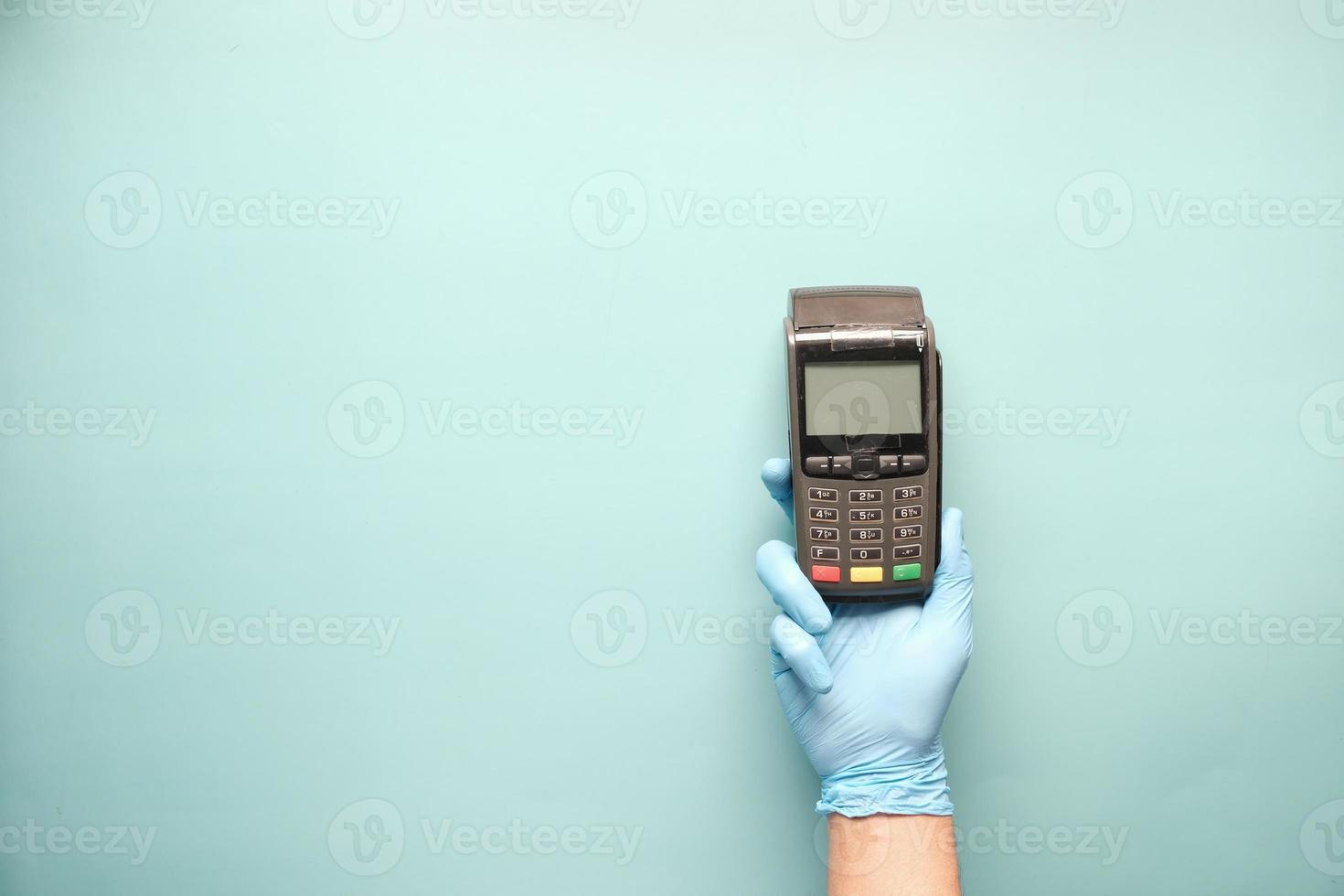 hand in a latex gloves holding pos machine photo