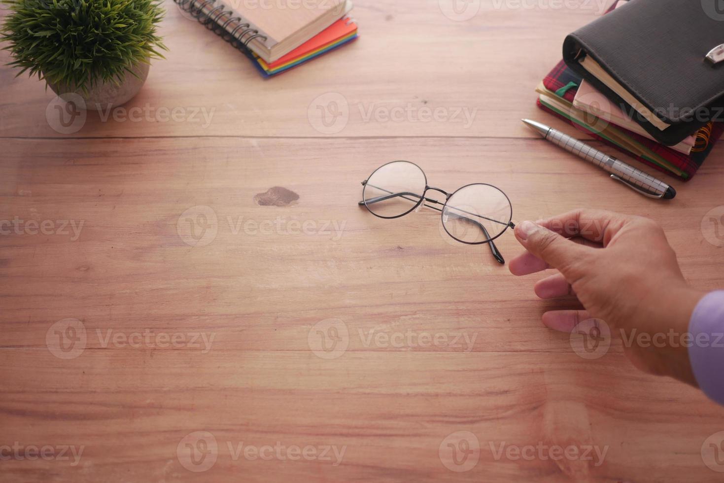 rear view of man hand holding old eyeglass on table photo
