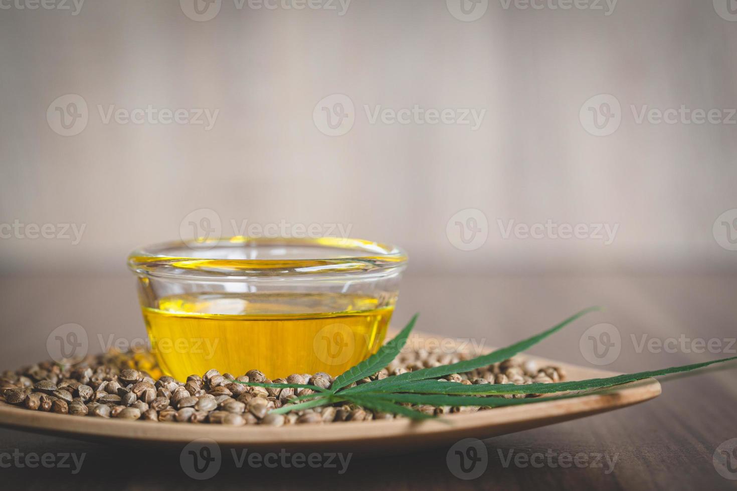 Hemp oil extracted in a bowl placed near the seeds and leaves. Composition of extraction. Organic herbal medicinal products. Treatment of disease. Alternative medicine. photo