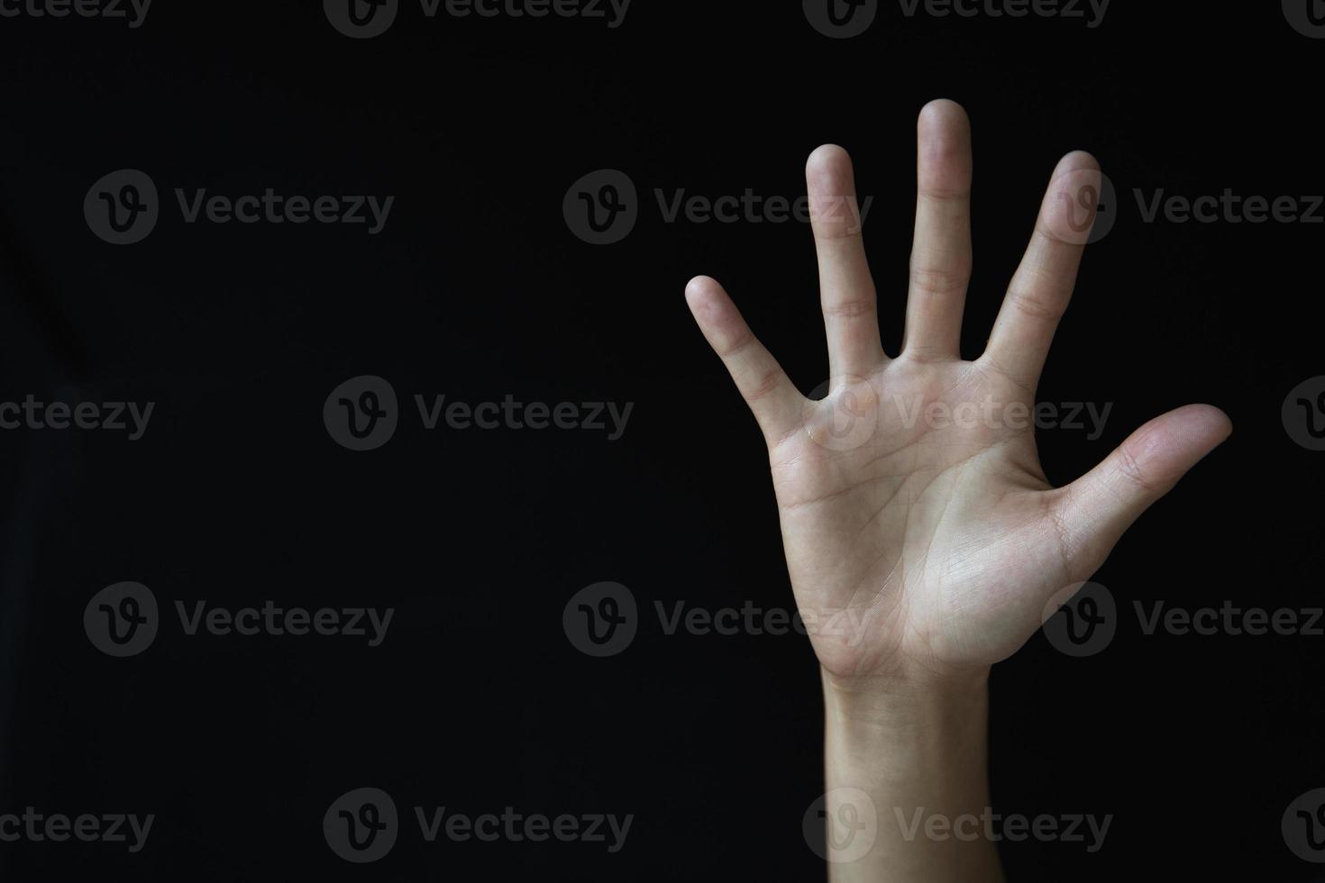 Woman's palm on black background. Abused woman. Stop violence and abuse of women. International Women's Day. photo