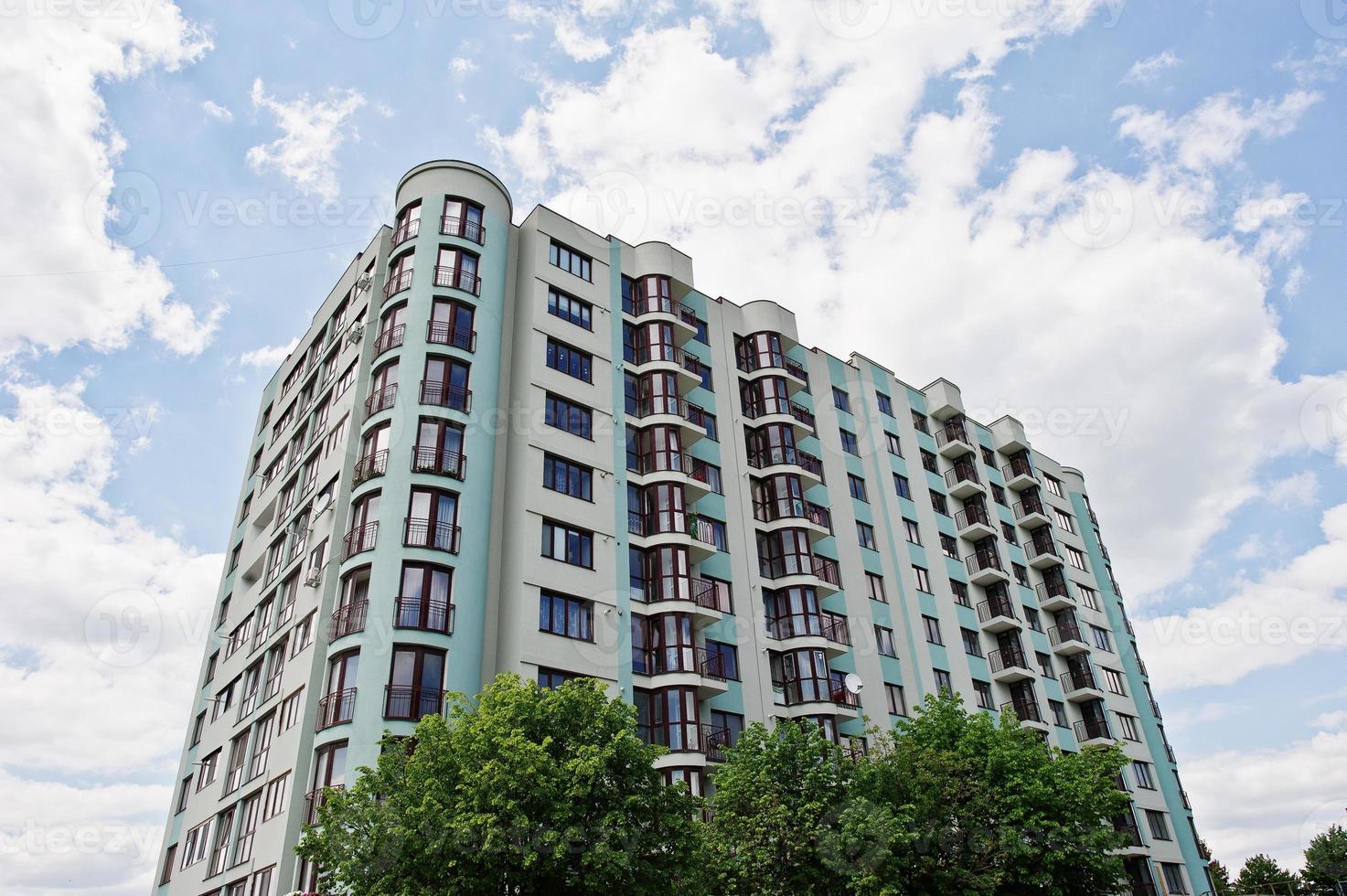 Balcony of new modern turquoise multi storey residential building house in residential area on sunny blue sky. photo