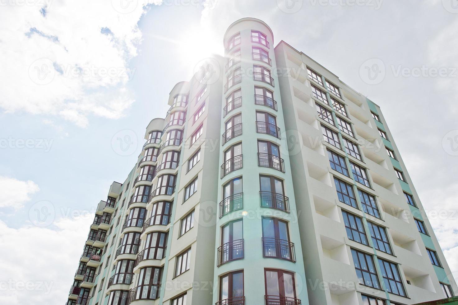 Balcony of new modern turquoise multi storey residential building house in residential area on sunny blue sky. photo