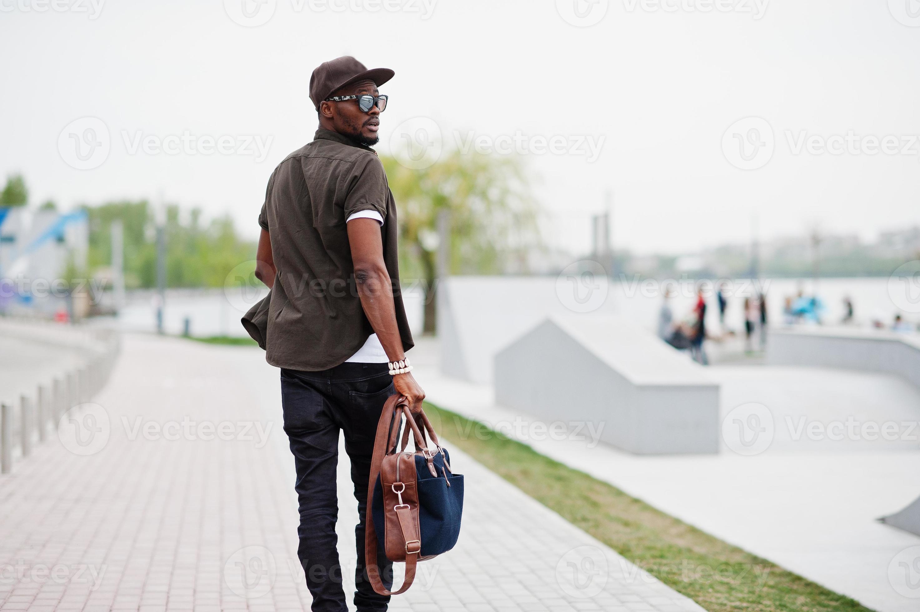 Back view portrait of walking stylish african american man wear on  sunglasses and cap with handbag outdoor. Street fashion black man. 6749836  Stock Photo at Vecteezy