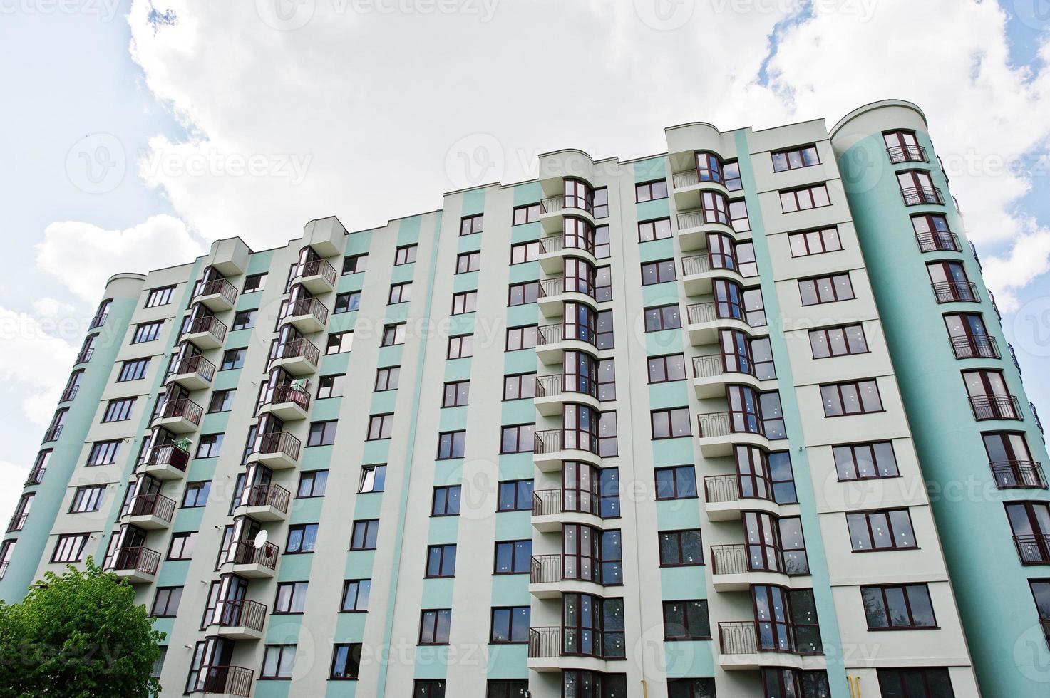 Balcony of new modern turquoise multi storey residential building house in residential area on sunny blue sky. photo