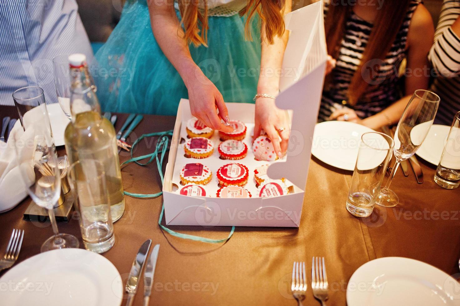 Happy bride receiving cupcakes as a present from her bridesmaids. Bachelorette party. photo