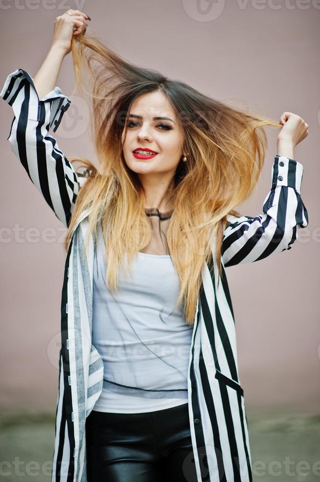 primer plano retrato de mujer de moda con chaqueta de traje a rayas blancas y negras, manos en el cabello. chica de moda emocional. foto