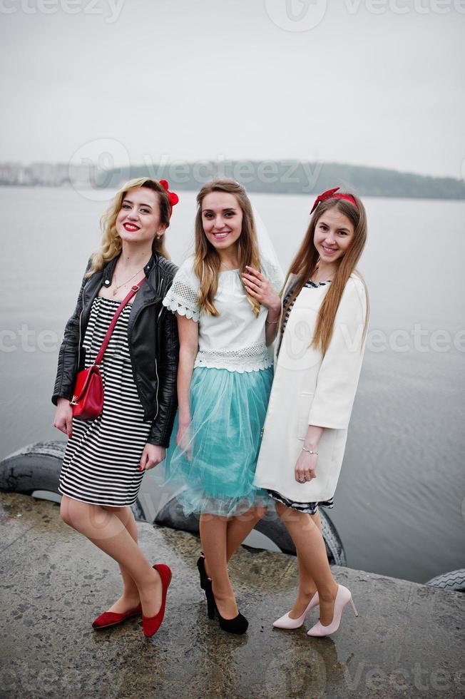 novia fantástica con sus dos damas de honor en el muelle al lado del lago en la despedida de soltera. foto