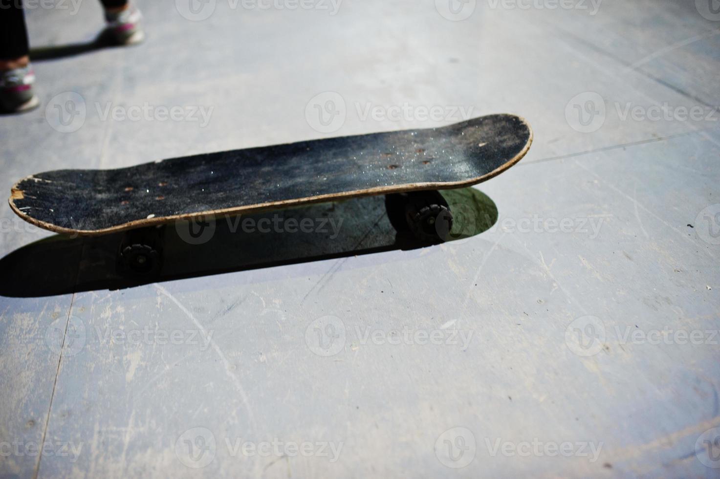 Skateboard with shadows on skate park at evening. photo