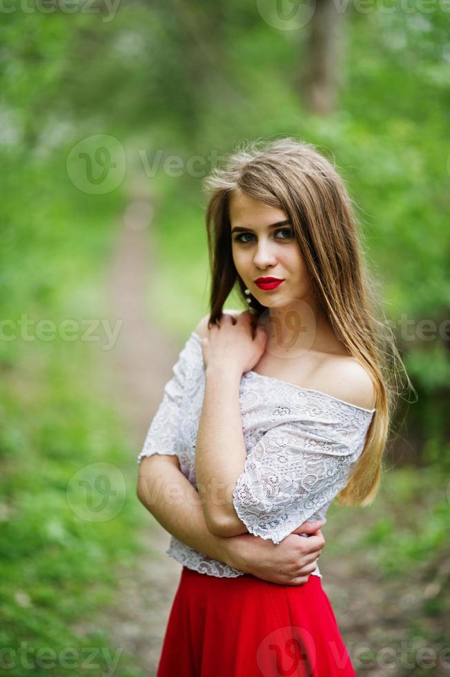 enlace Punto triste retrato de una hermosa chica con labios rojos en el jardín de flores de  primavera, vestido rojo y blusa blanca. 6750659 Foto de stock en Vecteezy