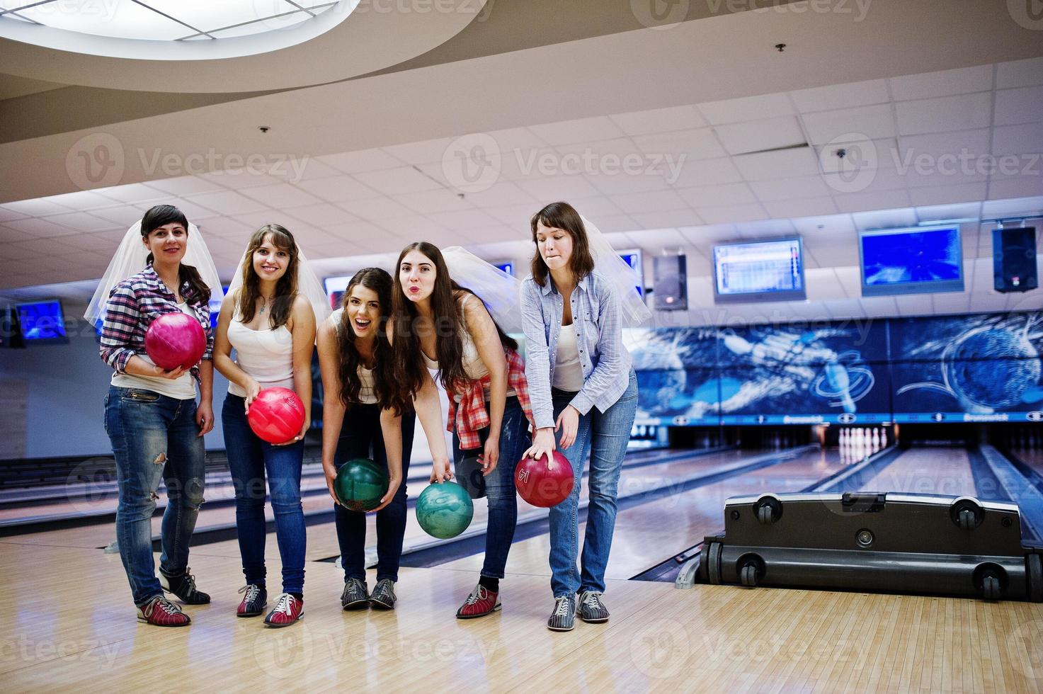 grupo de seis niñas con bolas de boliche en la despedida de soltera en el club de bolos. foto