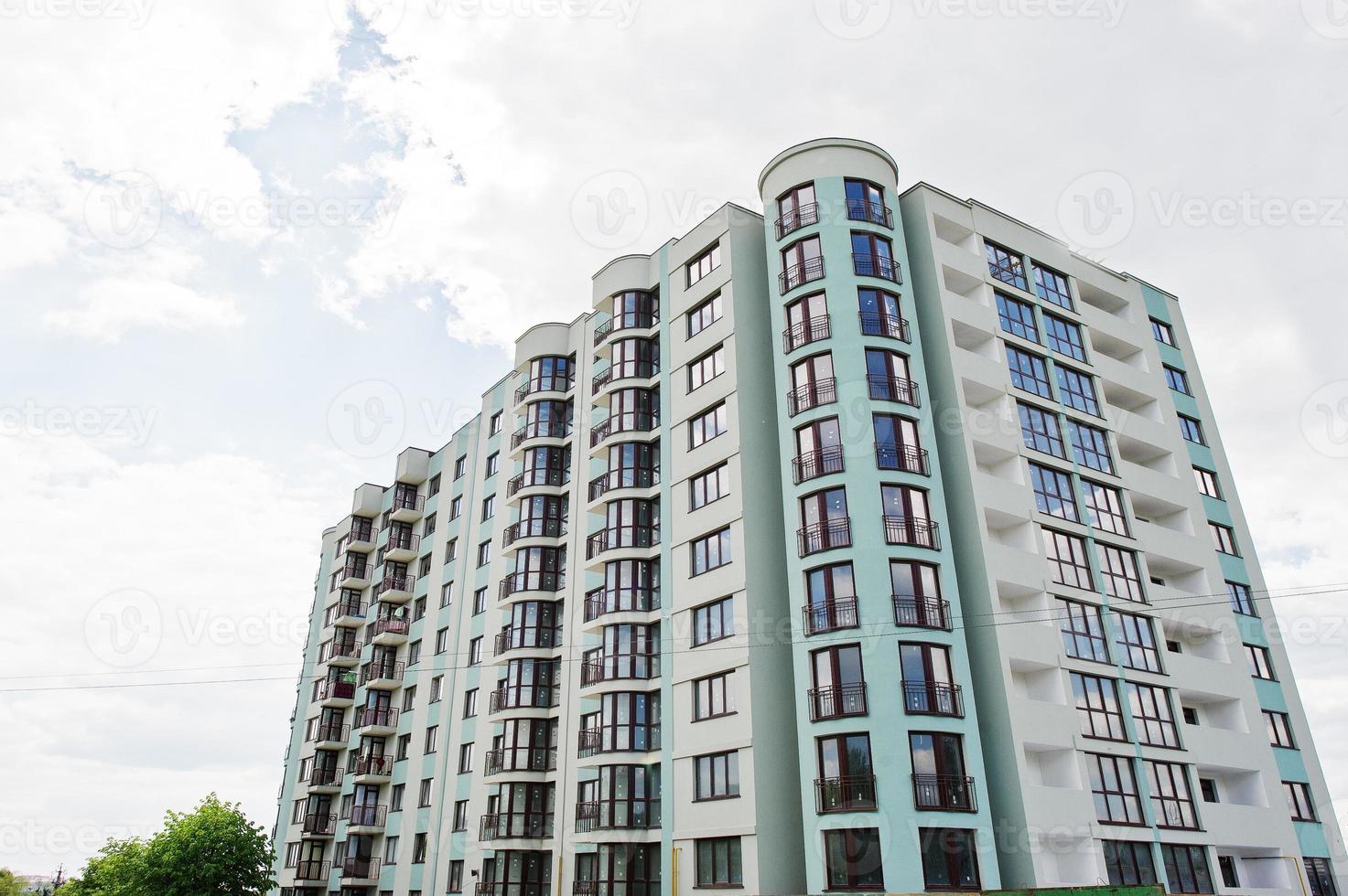 Balcony of new modern turquoise multi storey residential building house in residential area on sunny blue sky. photo