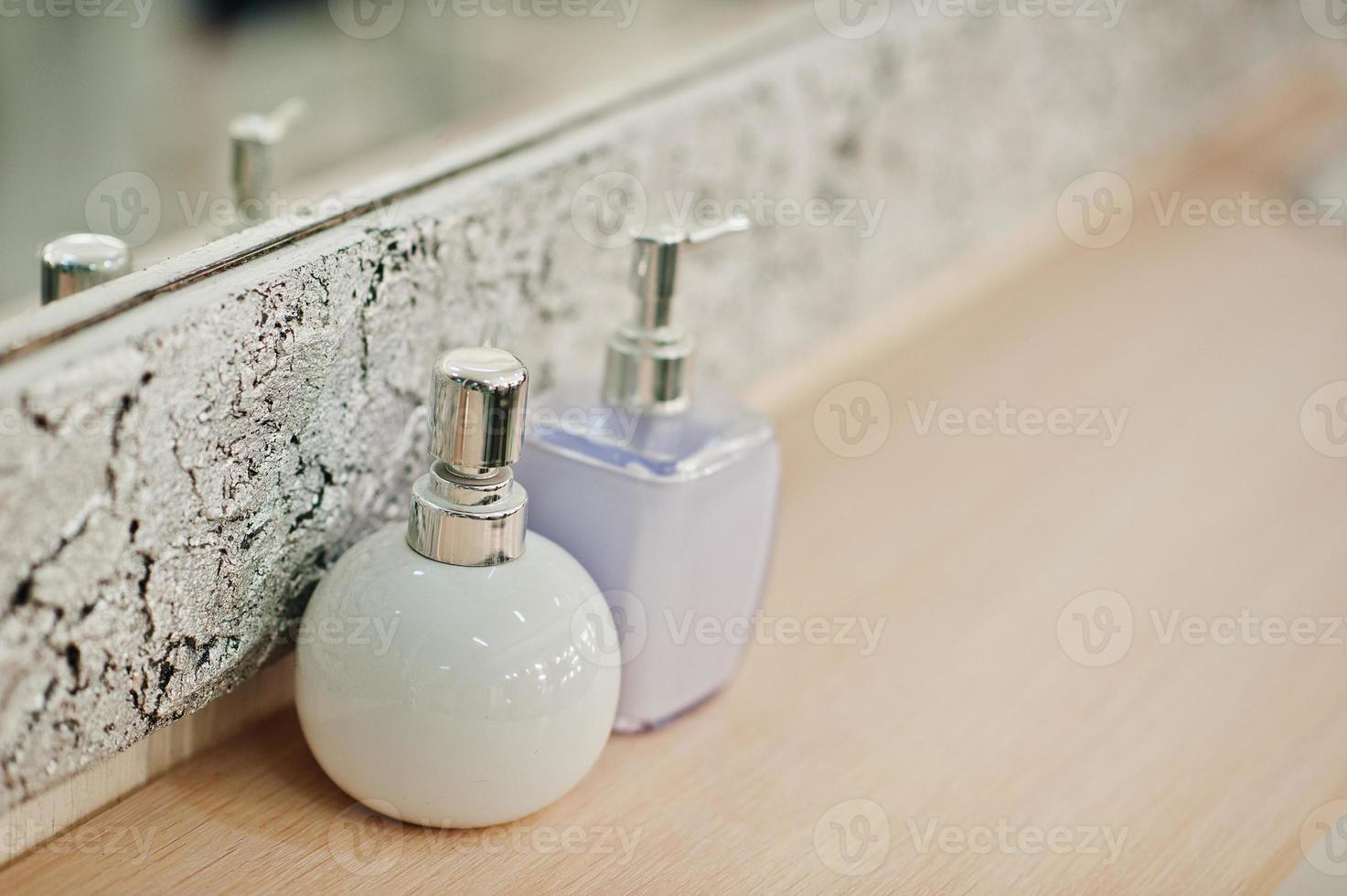 Two bottles at beauty salon against mirror. photo