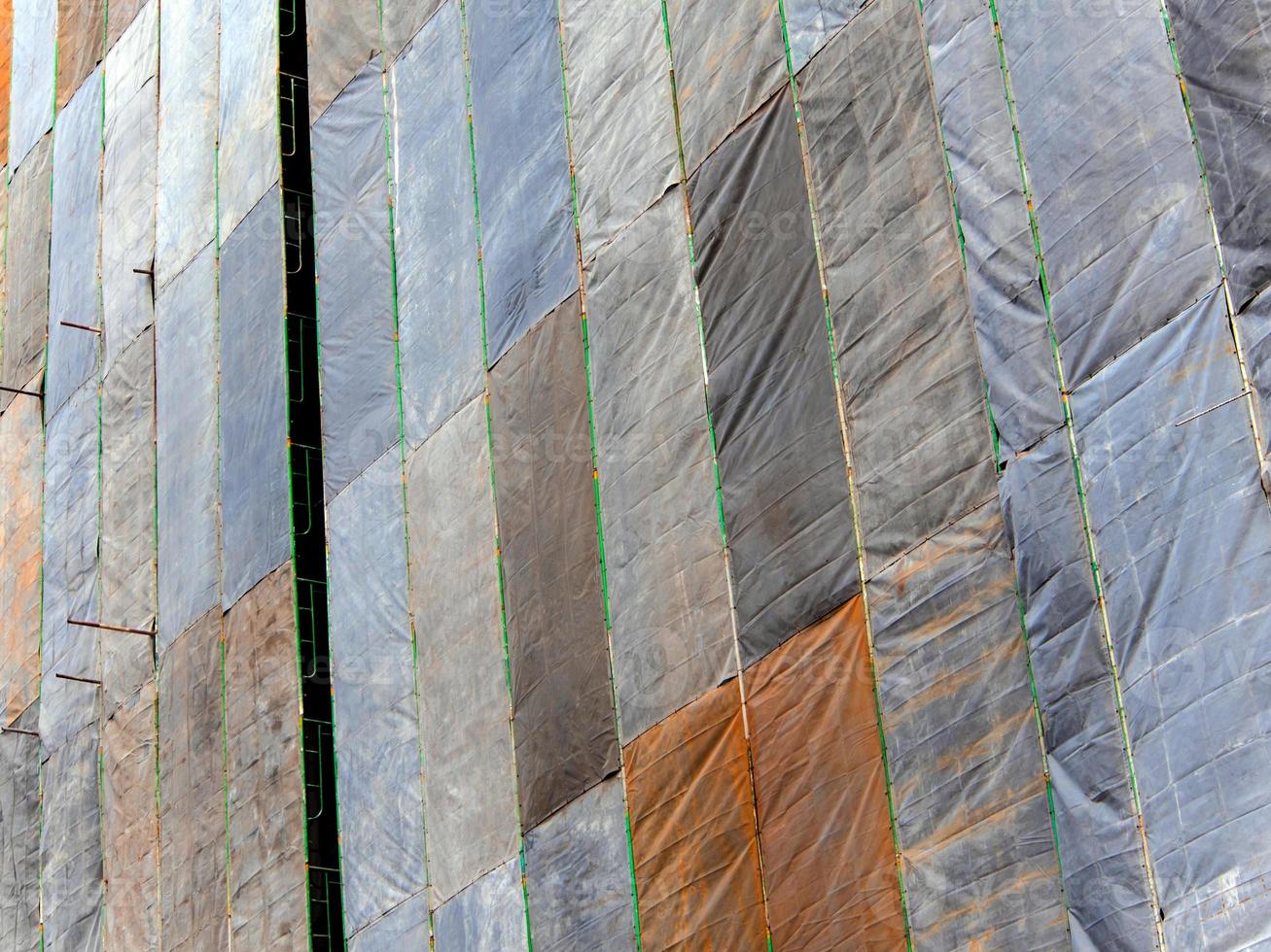 Several large canvases stretch together, Covered building under construction photo