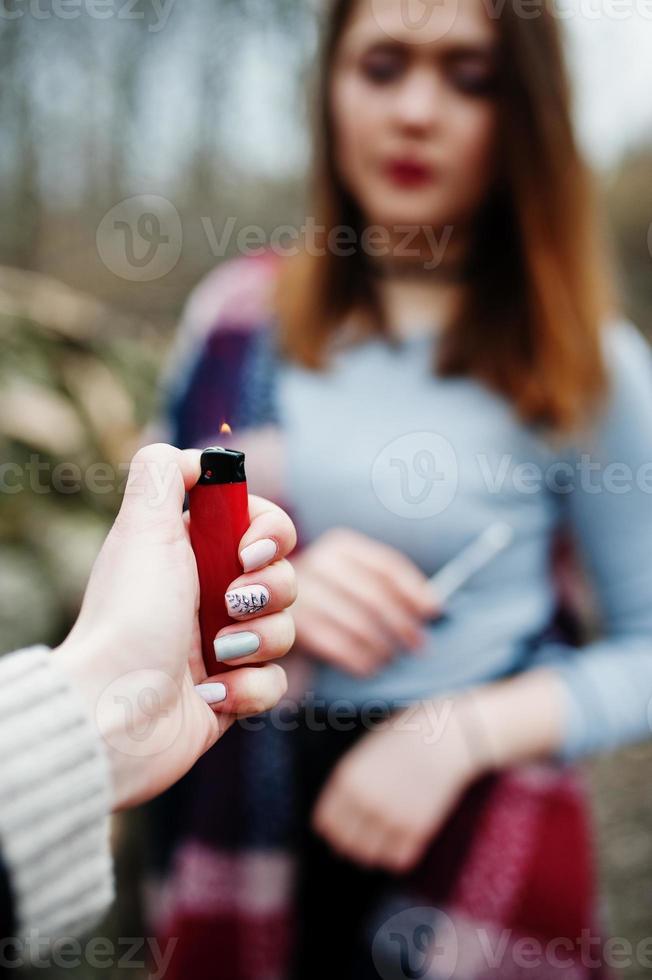 Hand of girl with cigarette lighter. Stop smoking social problem. photo