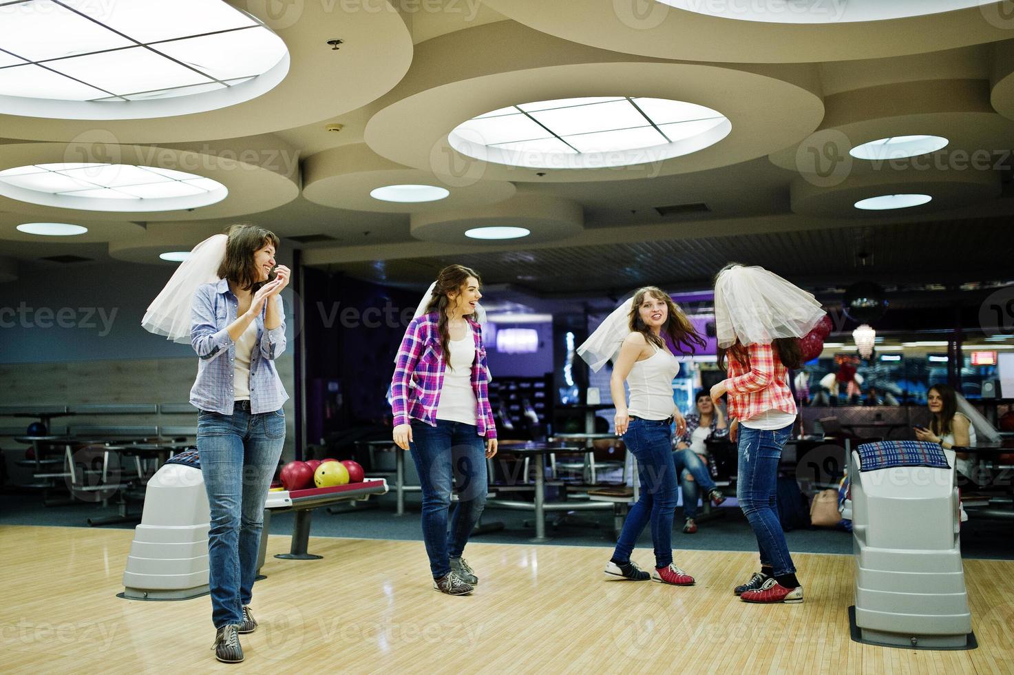 Group of girls having fun and play bowling at hen party. photo