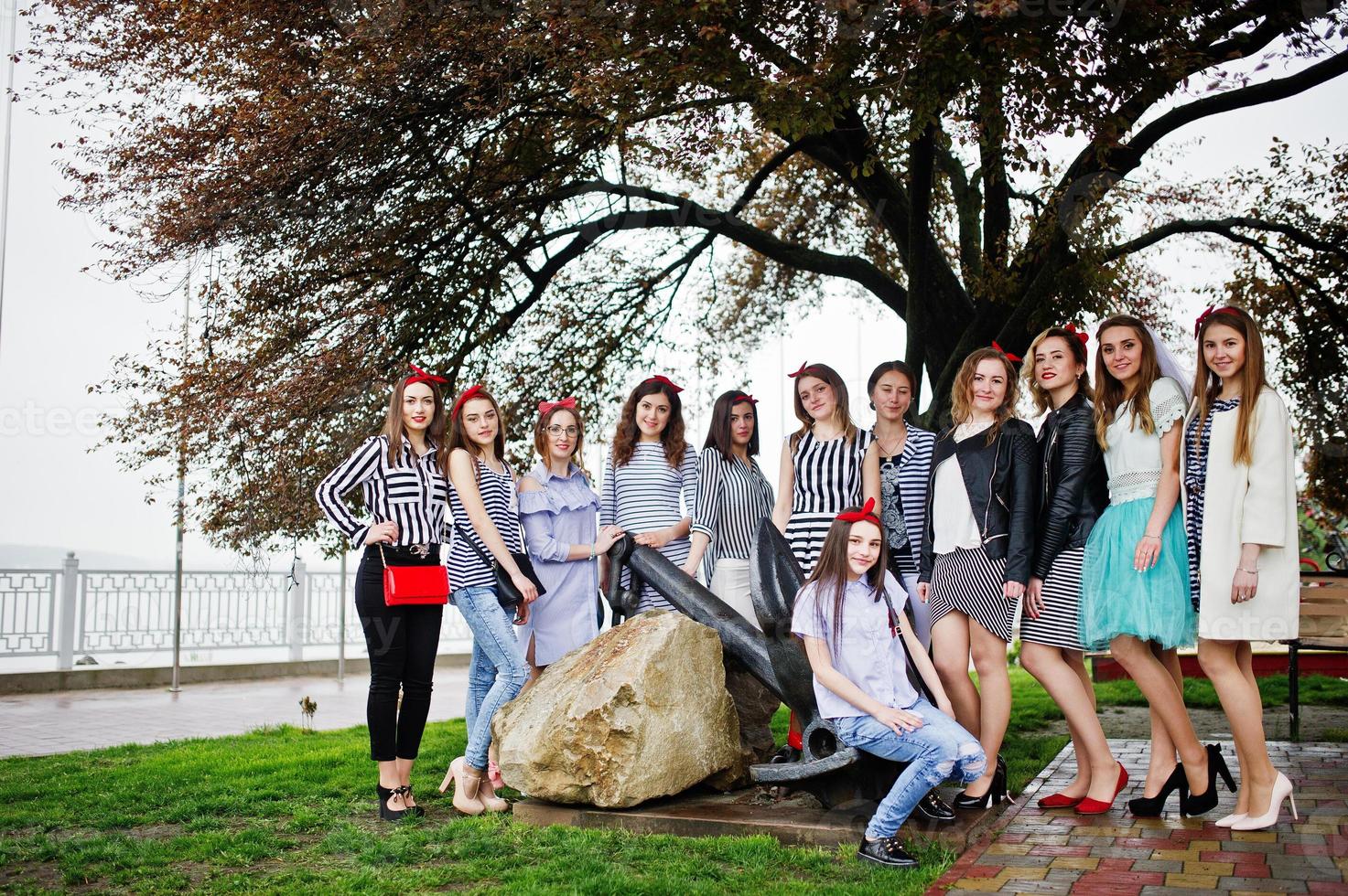 Pretty bridesmaids with beautiful bride posing under the tree in the park. Bachelorette party. photo