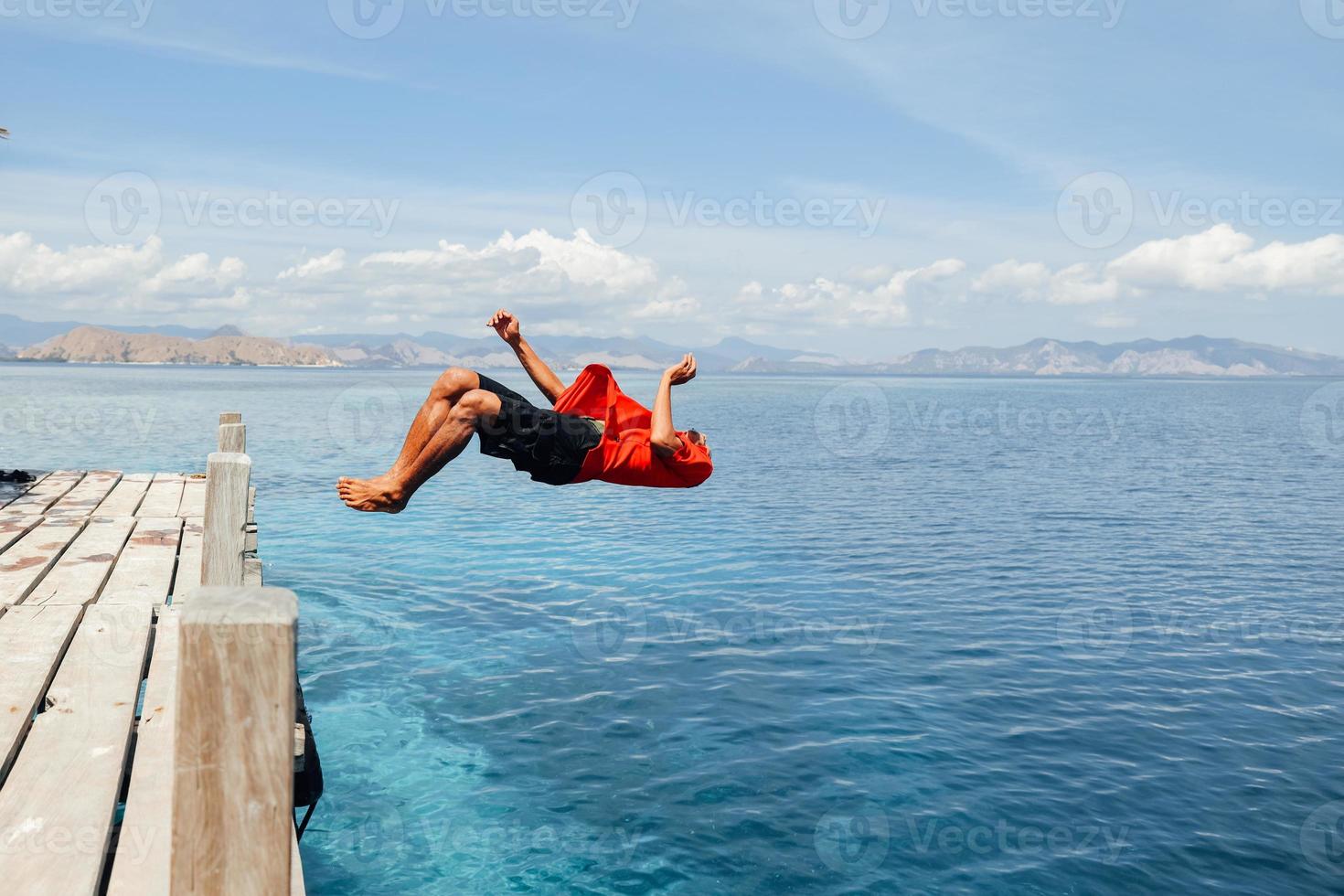 un hombre haciendo backflip en el agua de mar foto