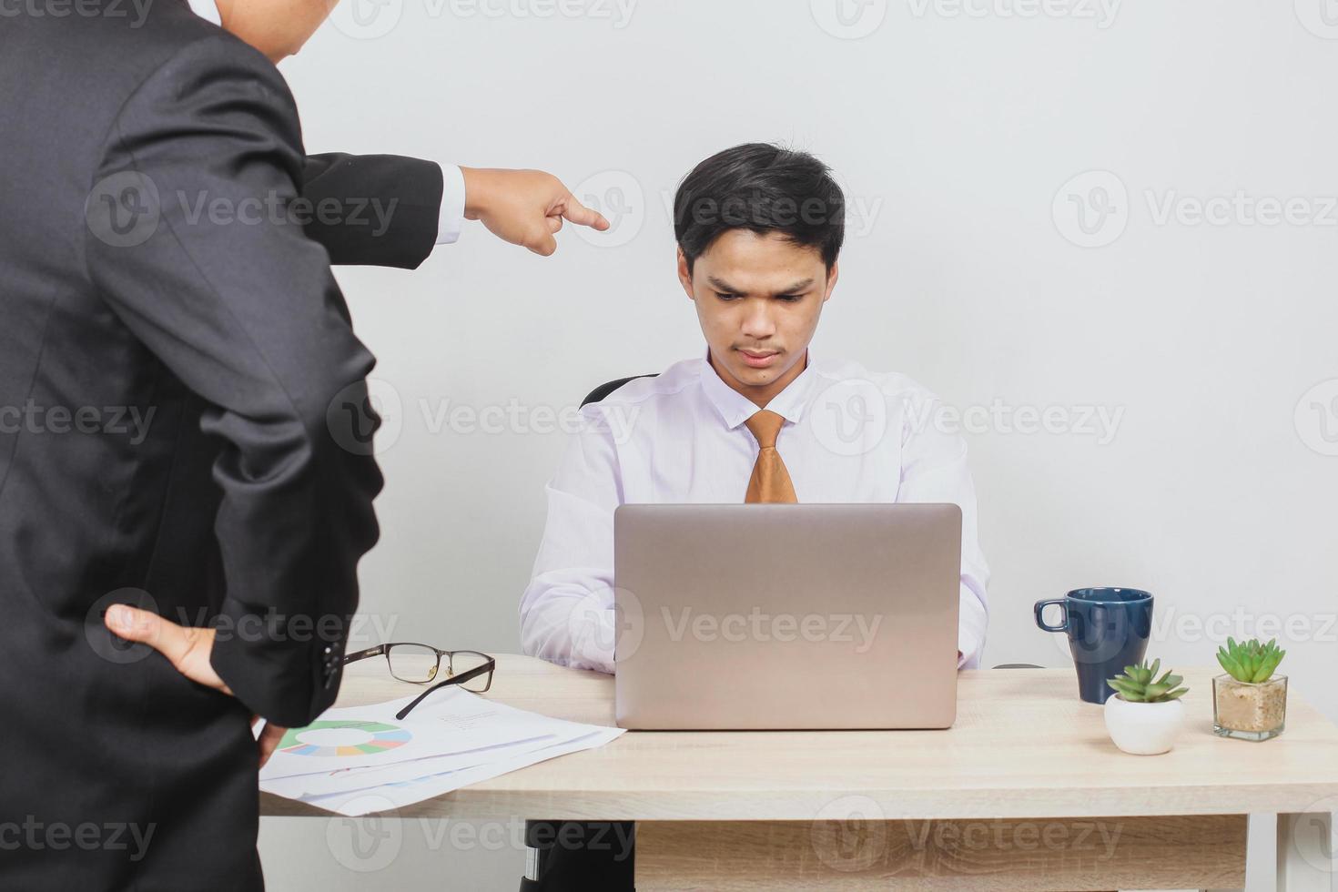 An employee is being scolded by his boss photo