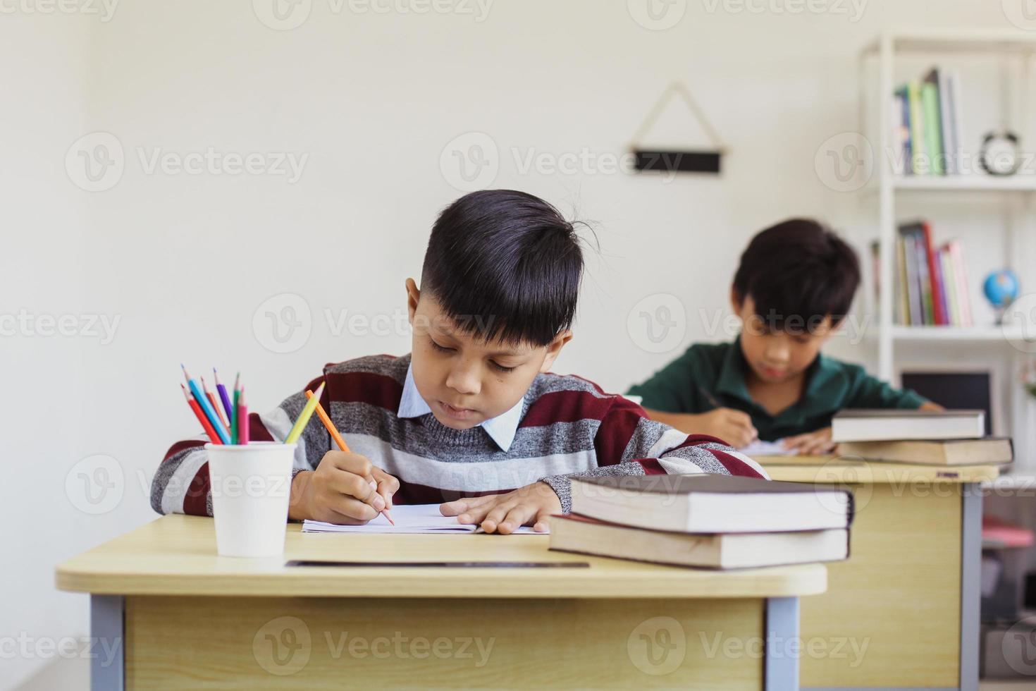 Serious Asian students studying in a classroom during a lesson photo