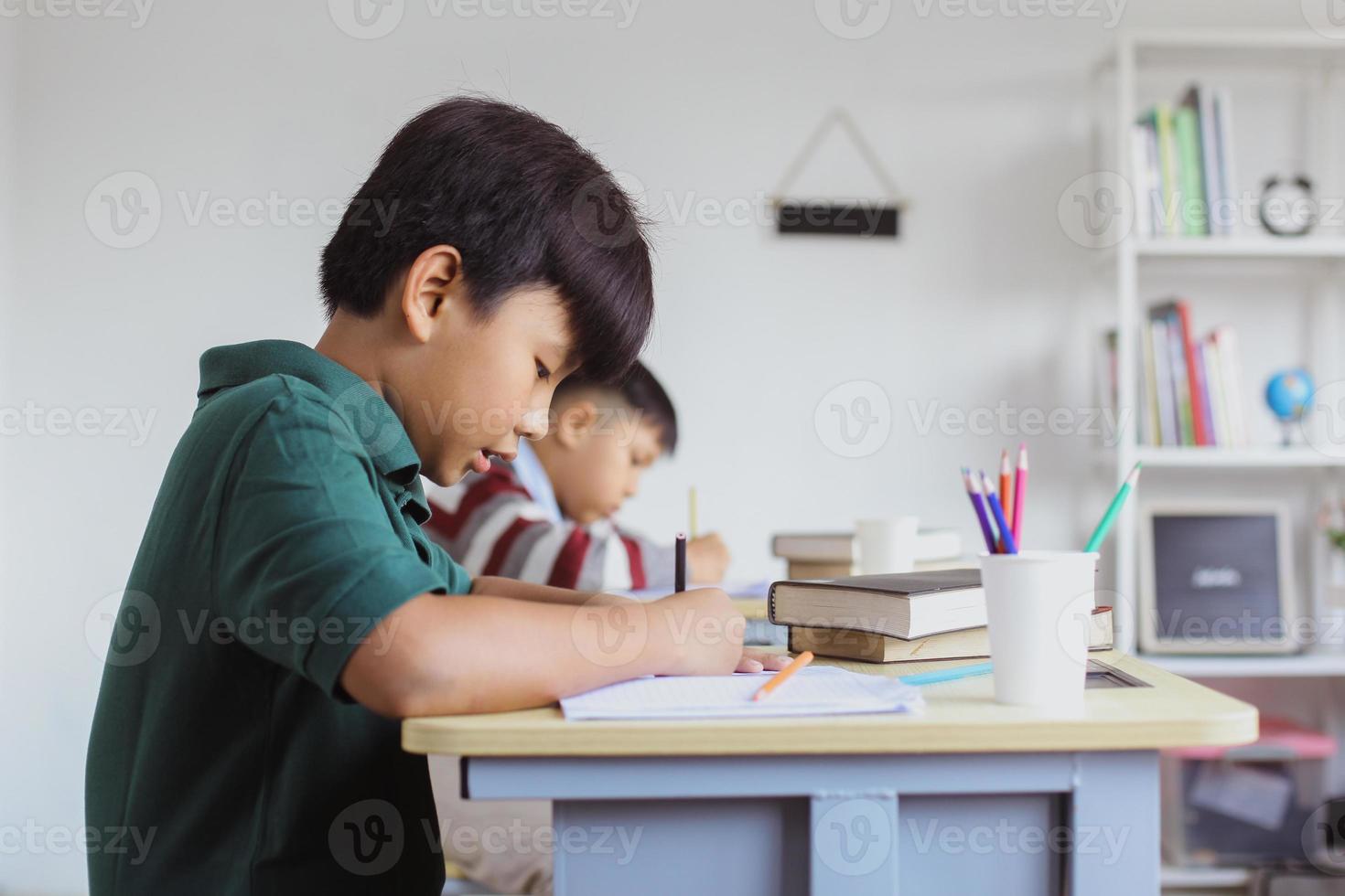 estudiantes asiáticos haciendo tareas escolares en clase foto