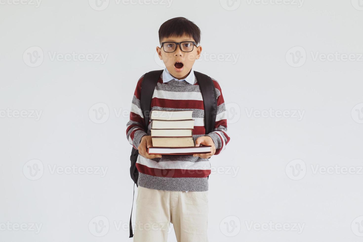 estudiante asiático sorprendido mirando a la cámara mientras sostenía una pila de libros foto