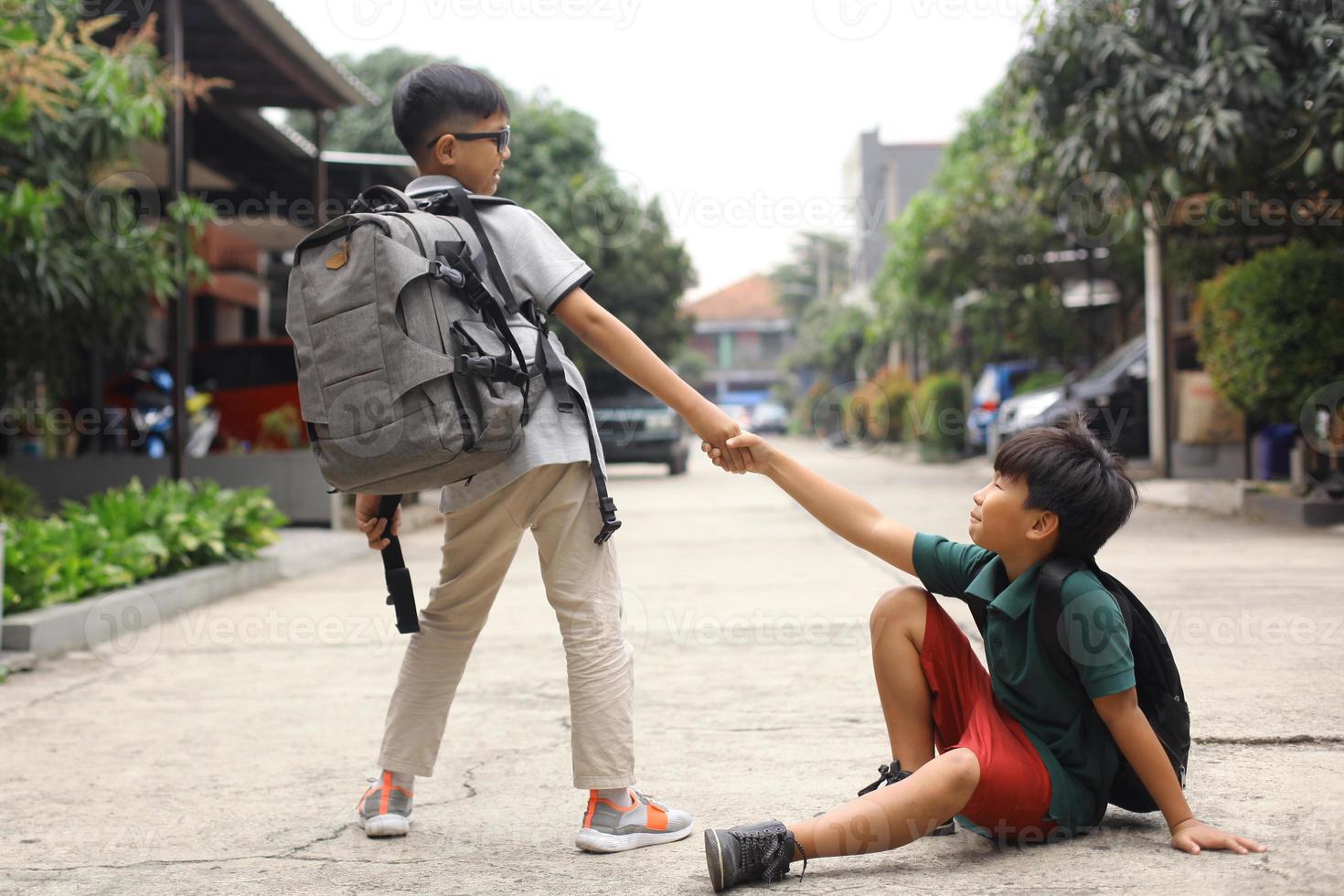 un estudiante ayuda a levantar a su amigo caído foto