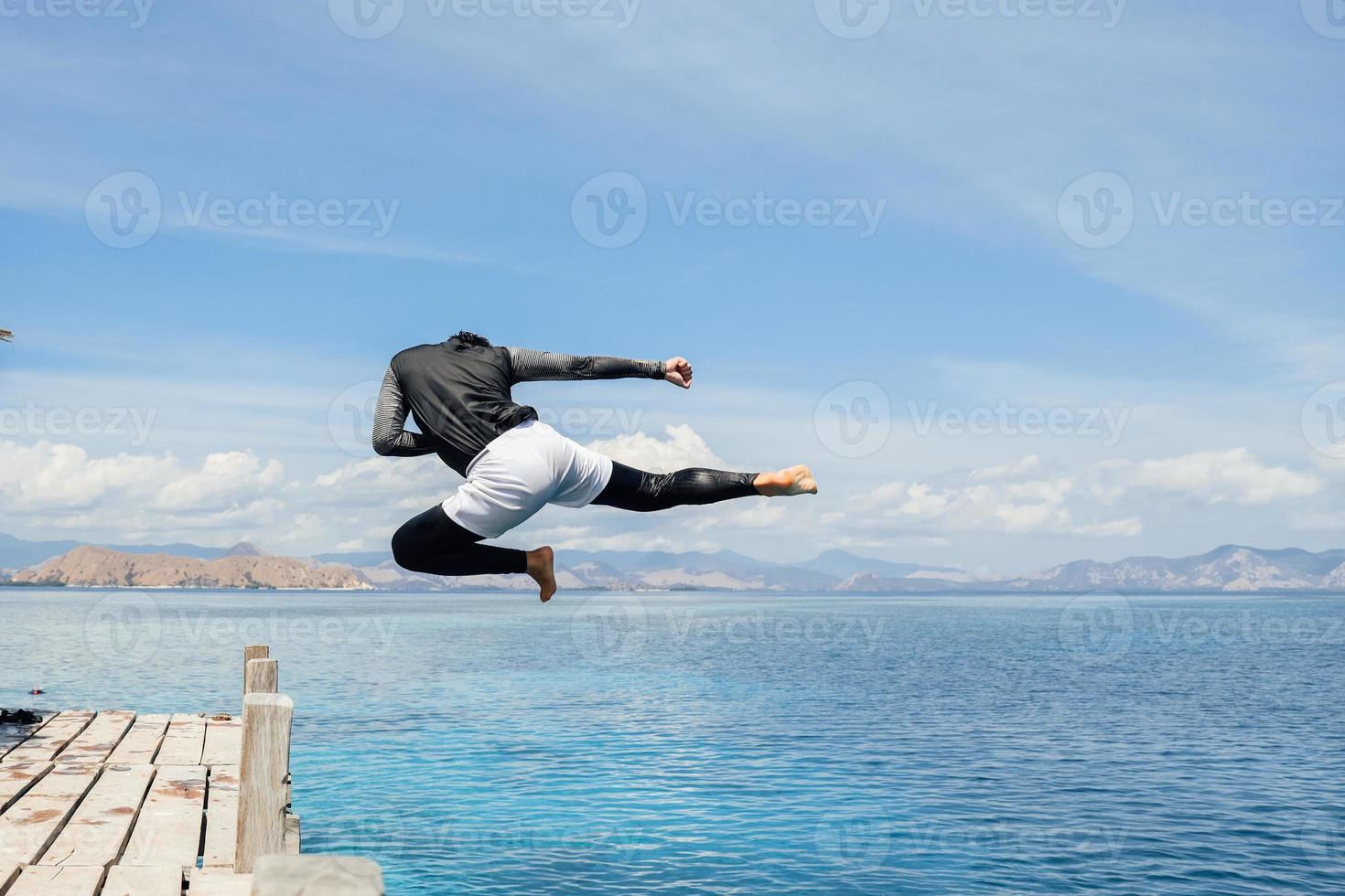 hombre saltando mientras patea en el agua foto