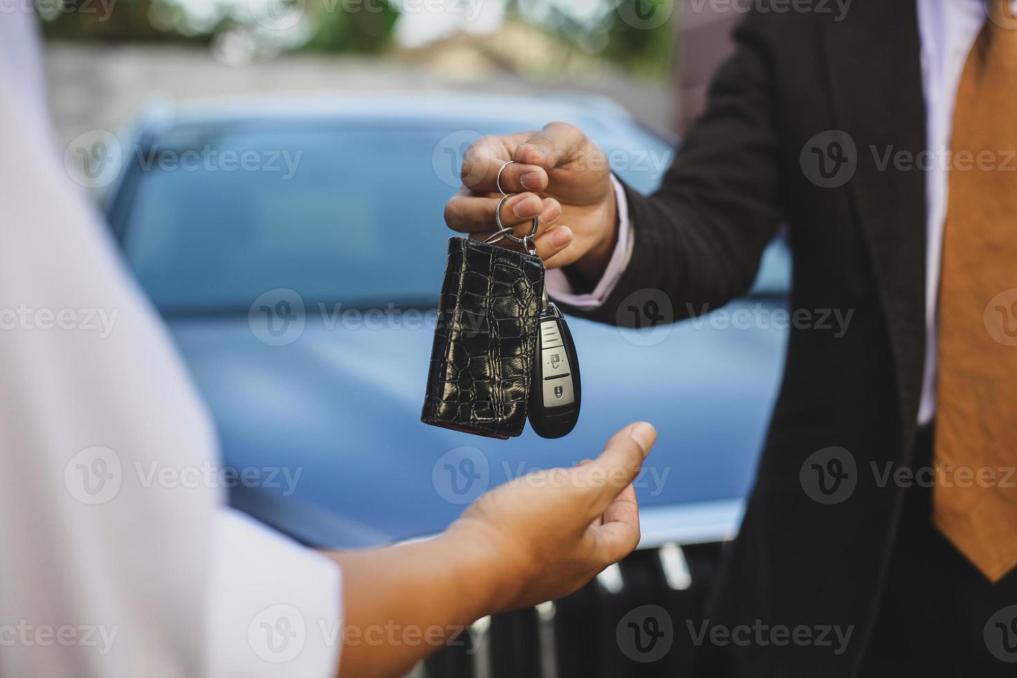 Car key handover from salesman to the owner photo