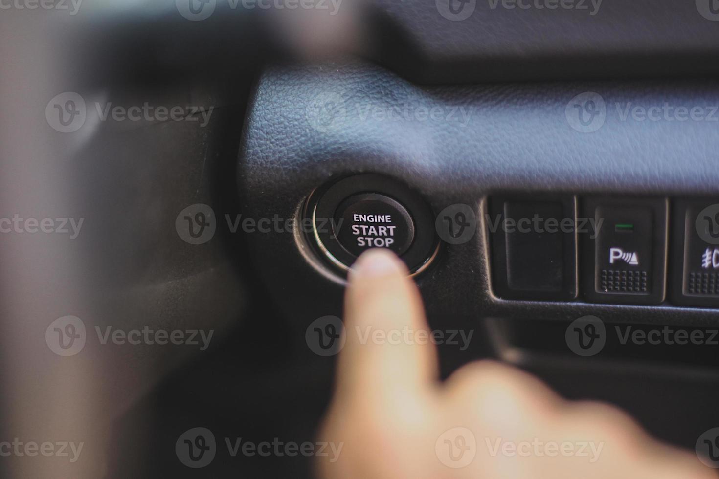 Empuje a mano el botón de arranque del motor para arrancar el coche. foto