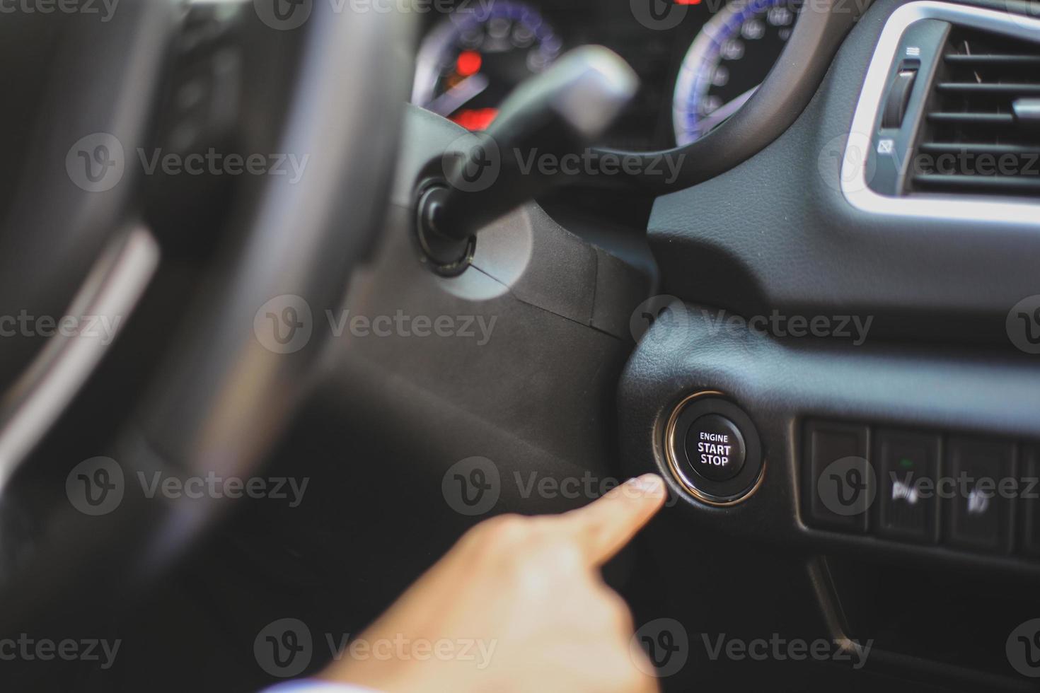 Hand push start stop button on the car dashboard photo