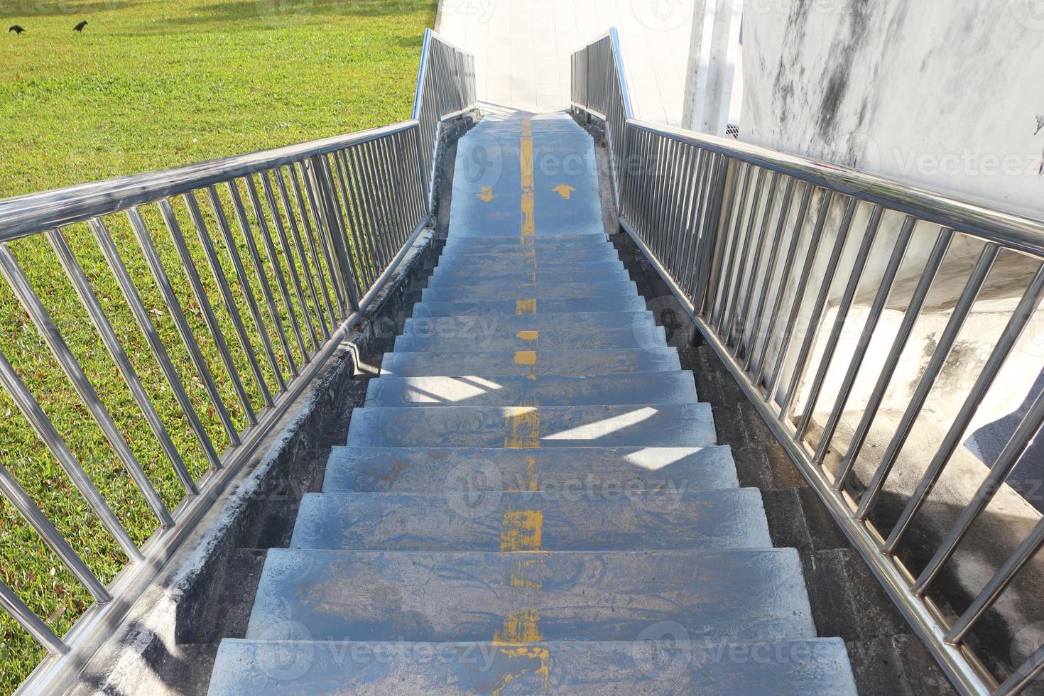 Concrete stairs of a footbridge with stainless steel handrails. photo