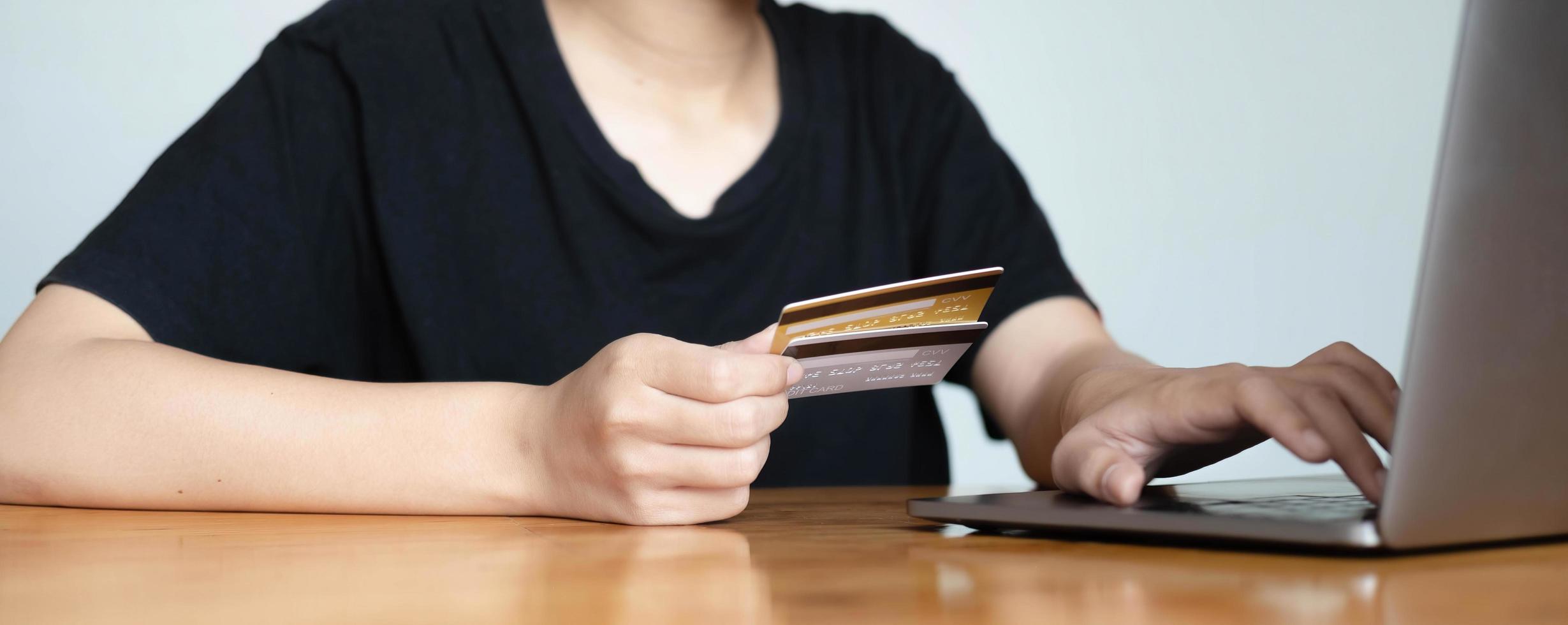 Close up woman hand using credit card and smartphone laptop for buying online shopping photo