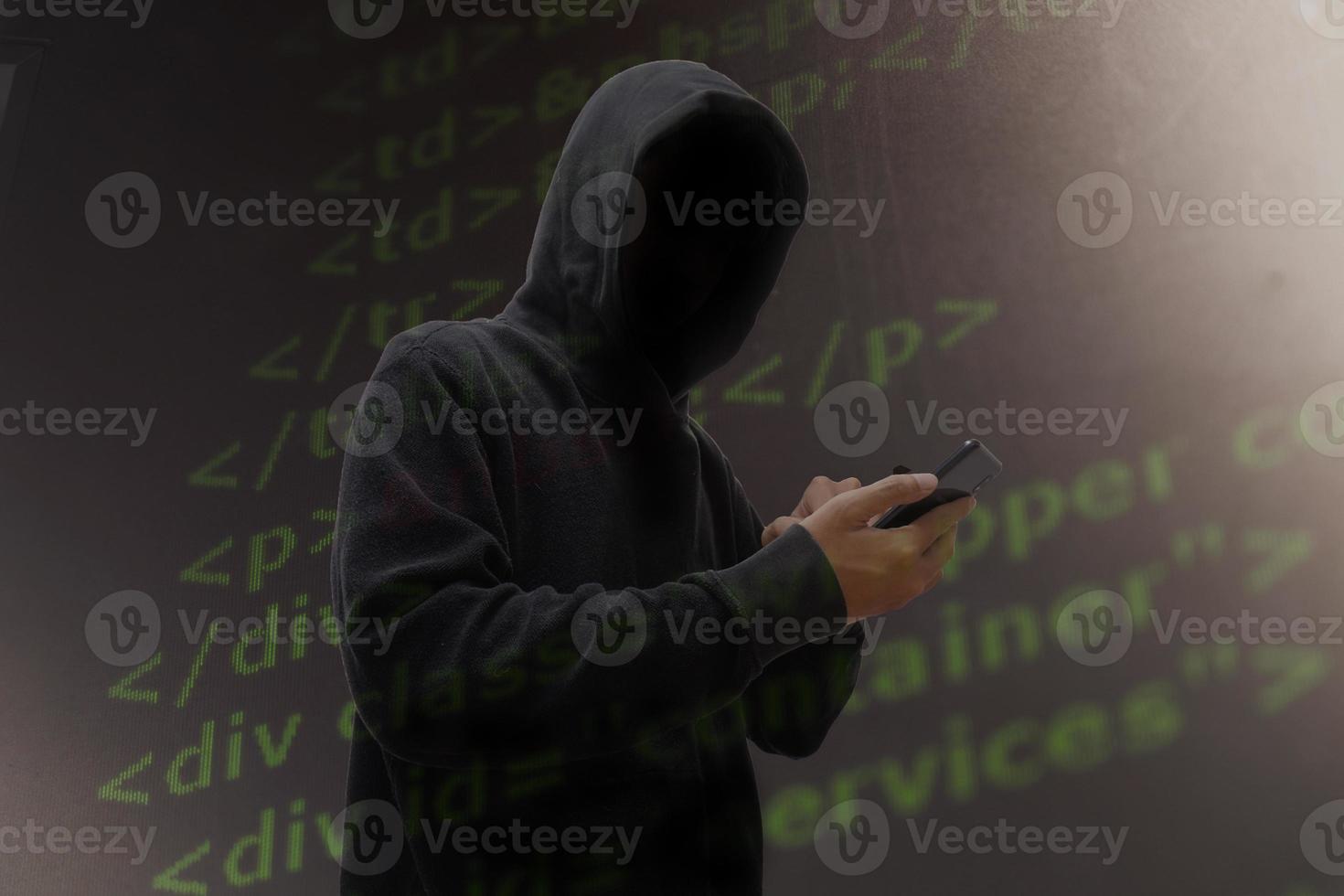 Computer hacker in mask and hoodie over abstract Data thief background. photo