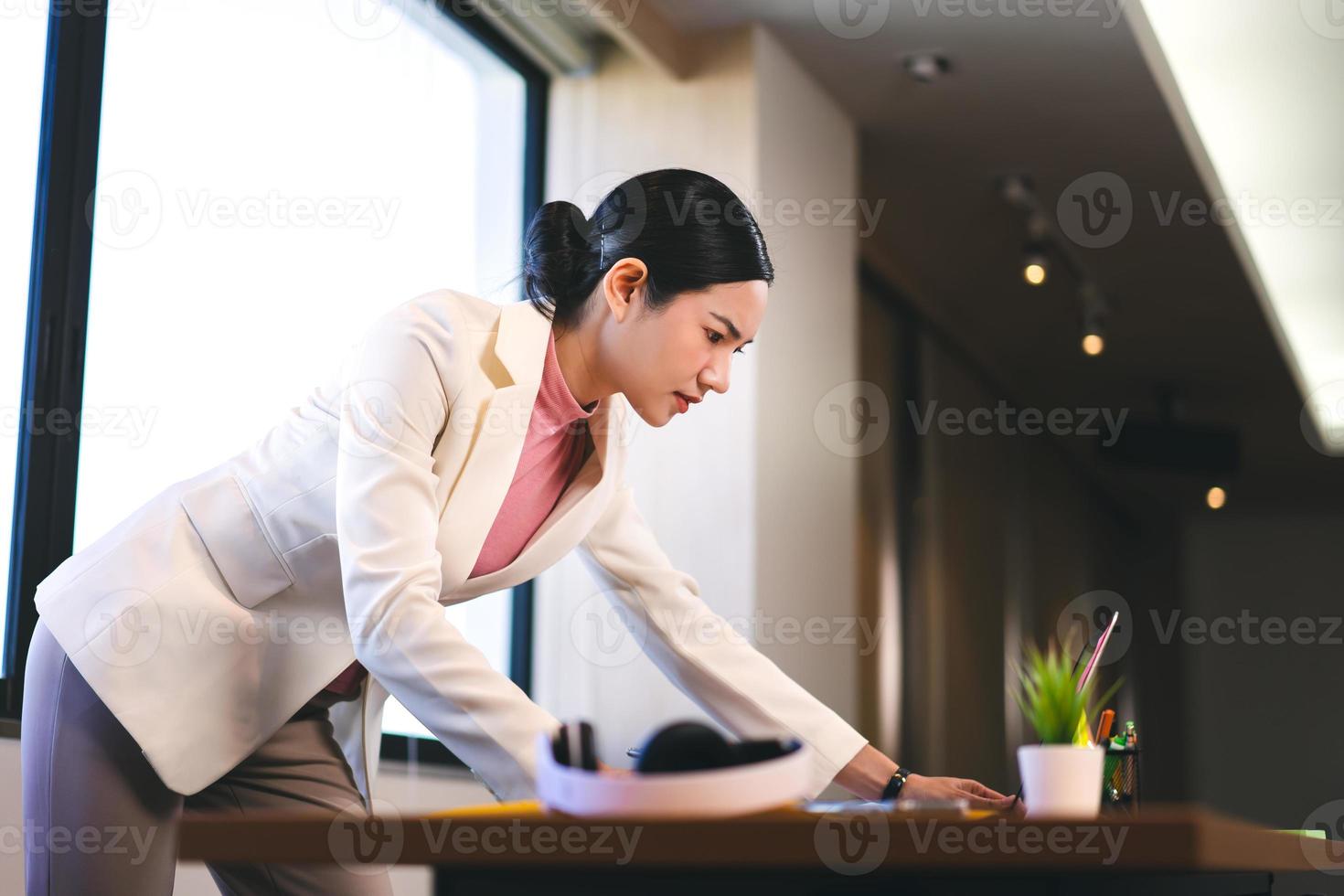 mujer trabajadora elegante asiática de negocios ocupados en la oficina. foto