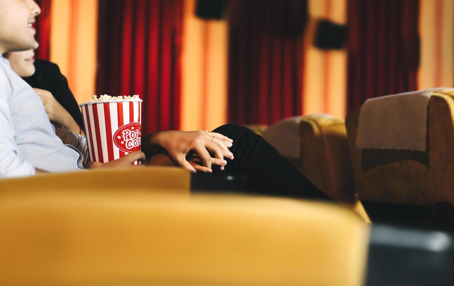 Adult caucasian lover couple in movie theater hand holding together photo