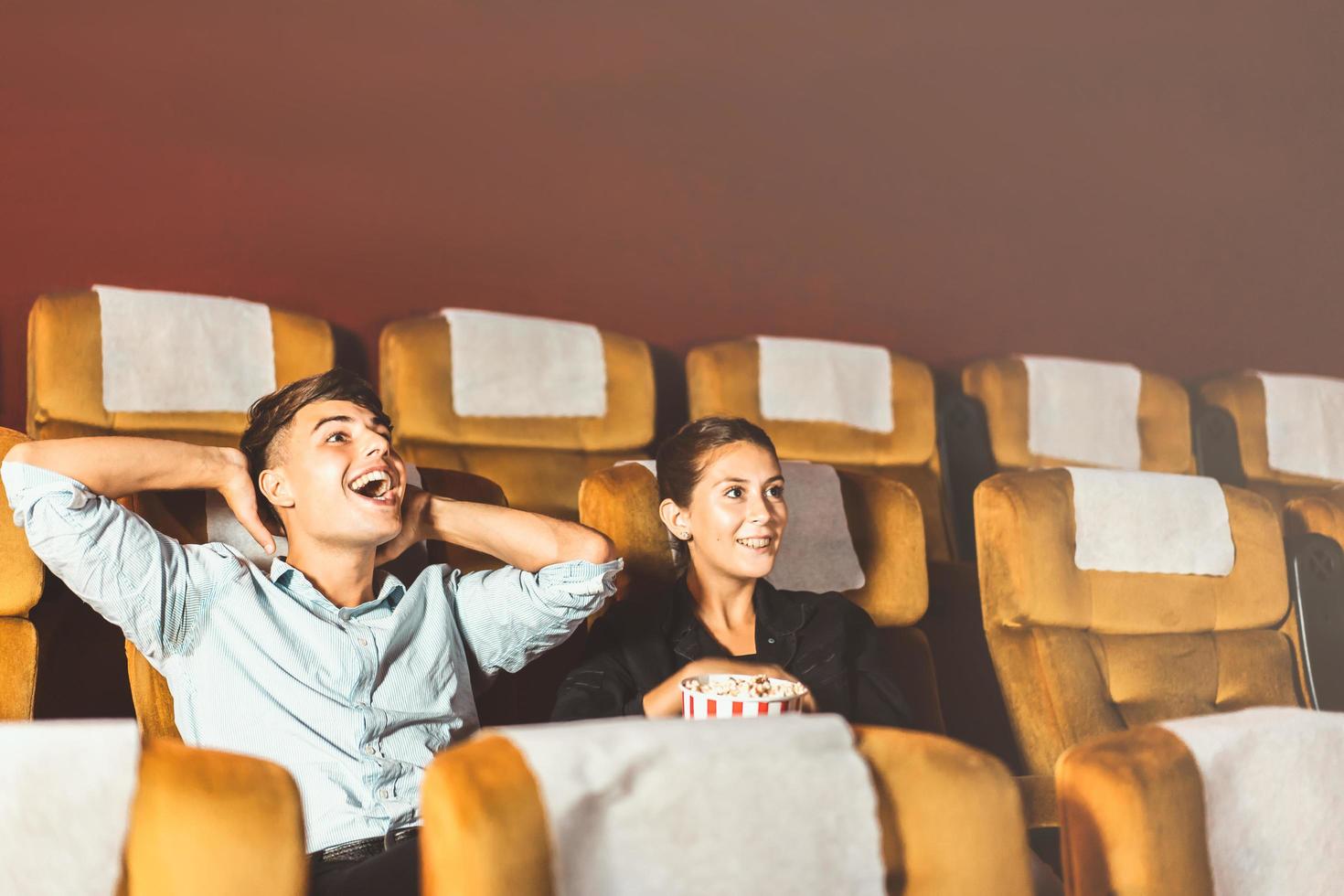 Caucasian man and woman watching a movie. photo