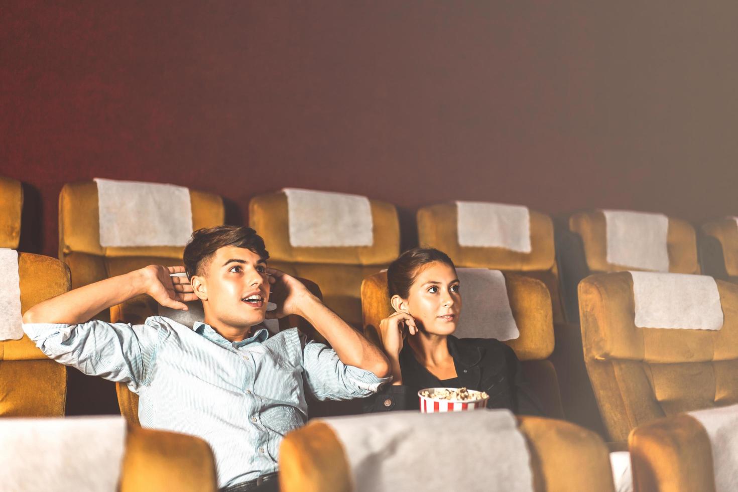 Caucasian man and woman watching a movie. photo