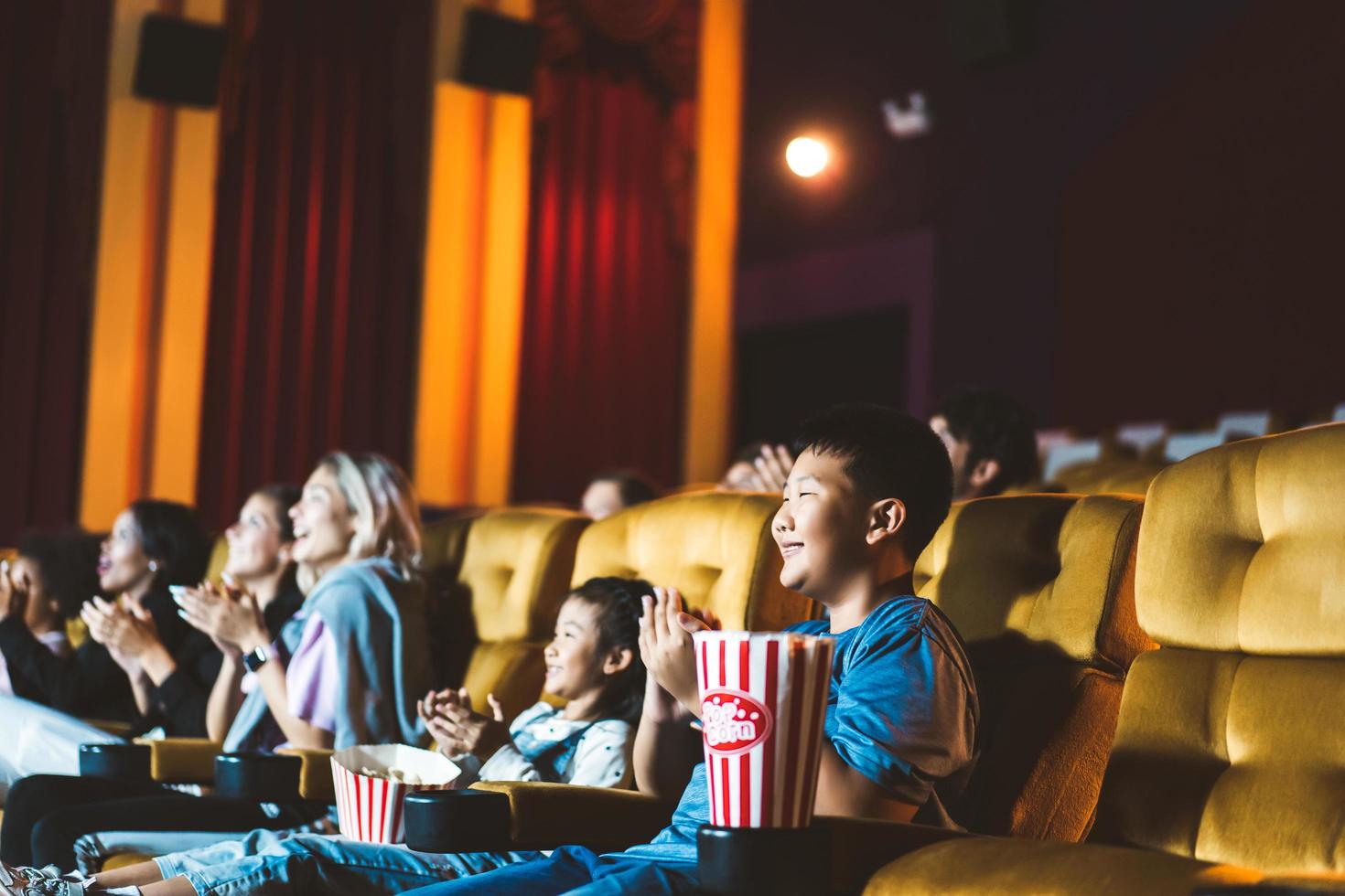 sonrisa feliz niños asiáticos viendo cine en el teatro foto