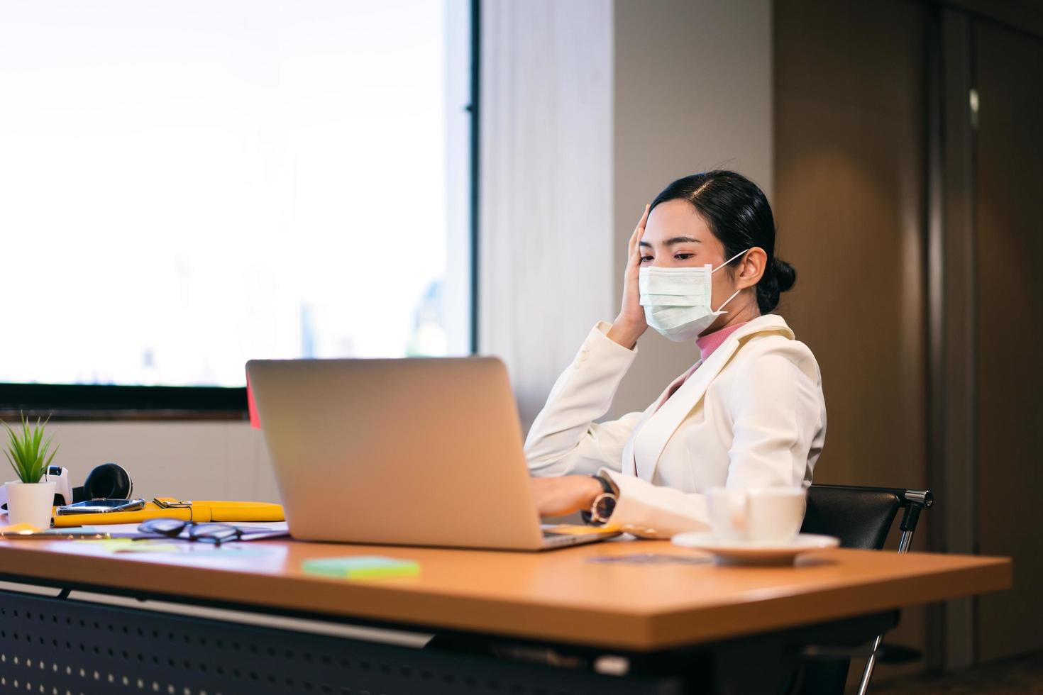 business working woman with mask has fever during virus outbreak at office. photo