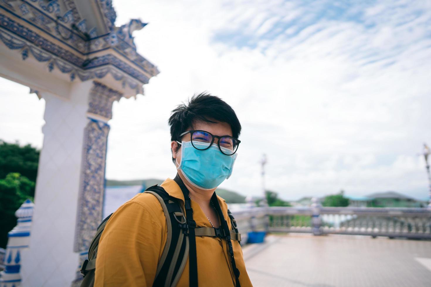 Adult asian traveller photographer man with mask on face for new normal outdoor lifestyle photo