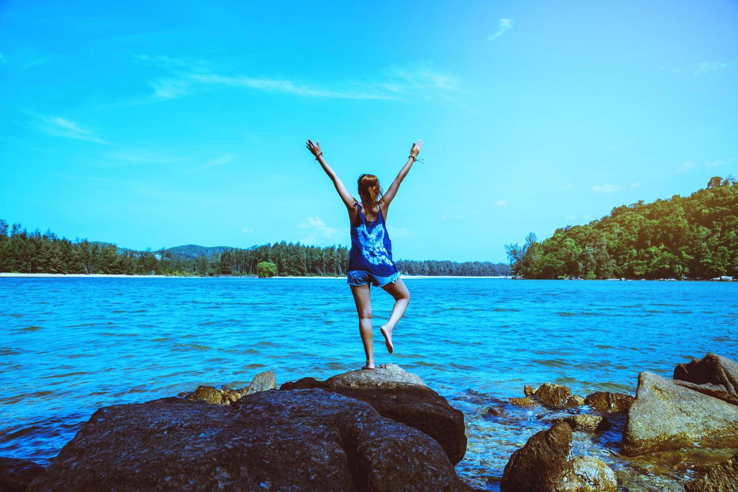 Asian women relax in the holiday. Travel relax.  Play if yoga. On the rocks by the sea. In the summer. Thailand photo