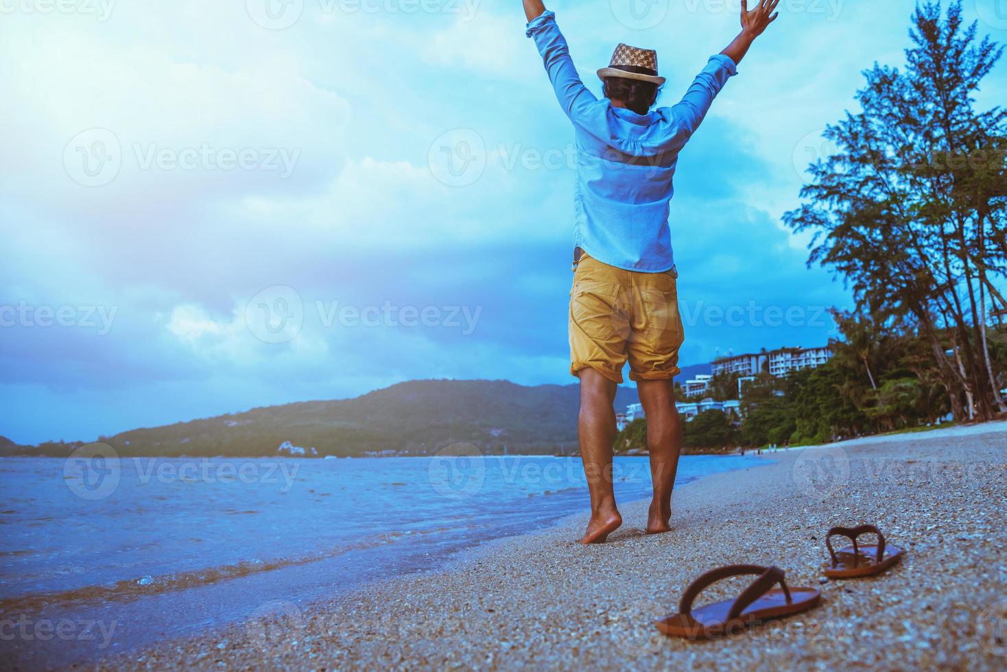 Asian man travel nature. Travel relax. Walking on the beach. In the summer photo