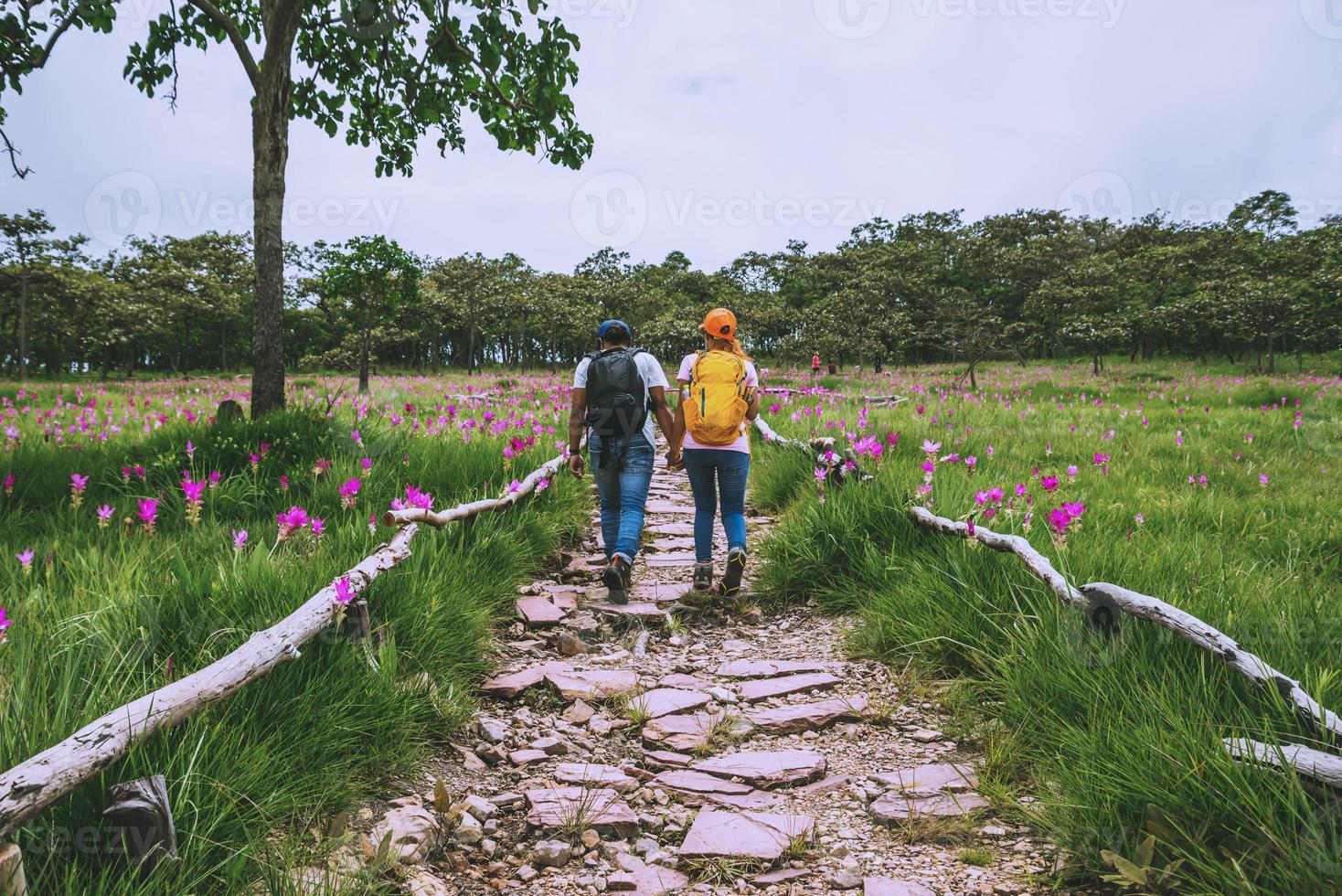 Amante mujer y hombre asiático viajes naturaleza. viajar relajarse. fotografía campo de flores de pepino sessilis. foto