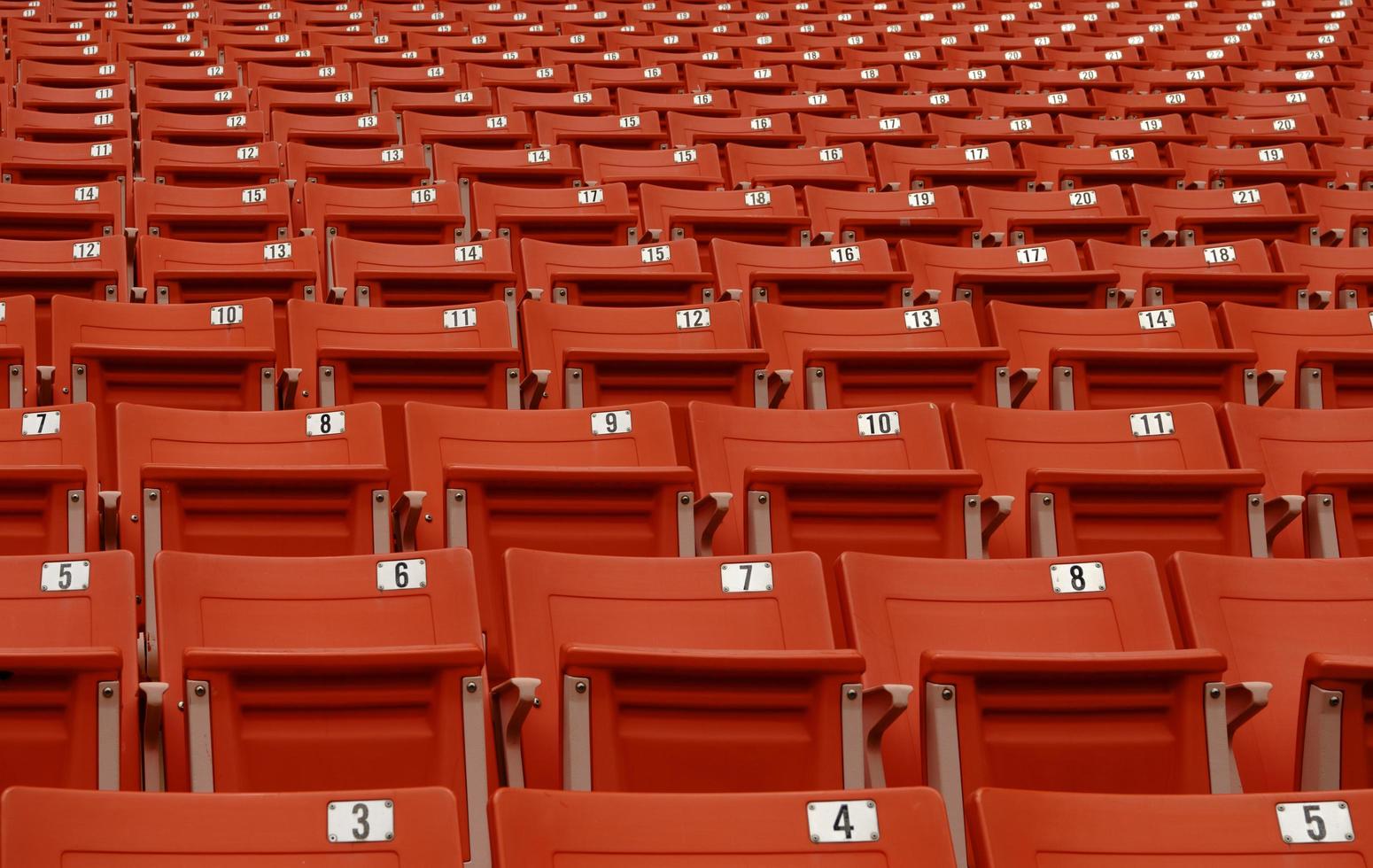 The seat to watch football has a number that has no people,red chair on football field photo