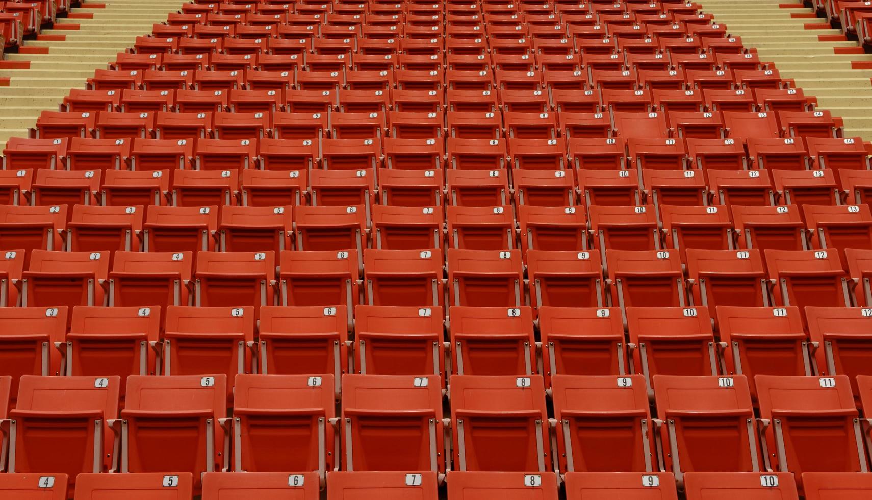 seat in a football field where no one is allowed to enter,Red chairs for watching football matches photo