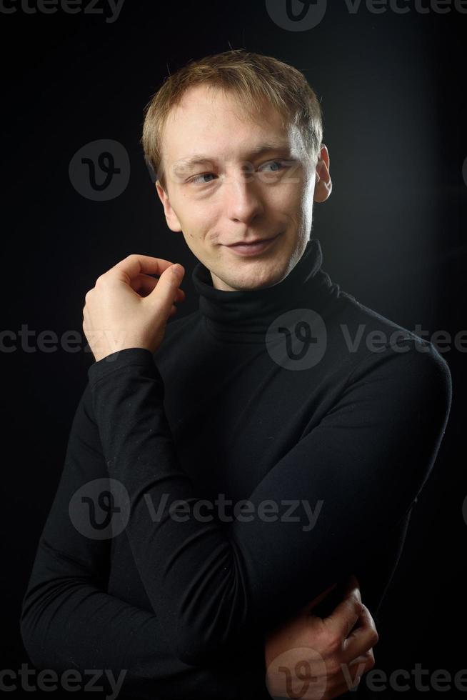 Portrait of determined goodlooking man wearing black shirt, black background. photo