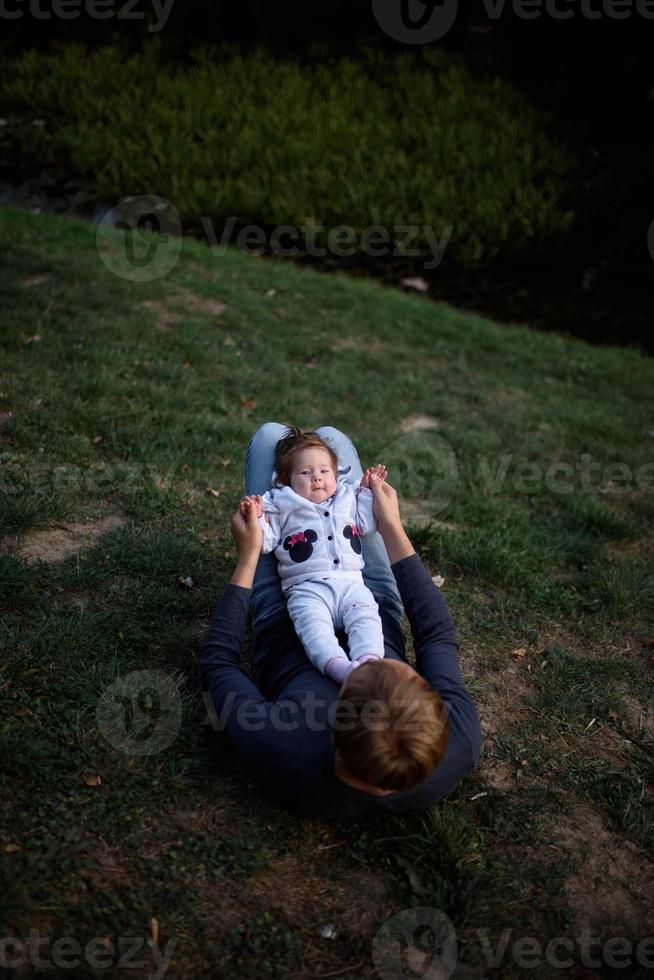 joven padre divirtiéndose con su pequeña hija en el parque foto